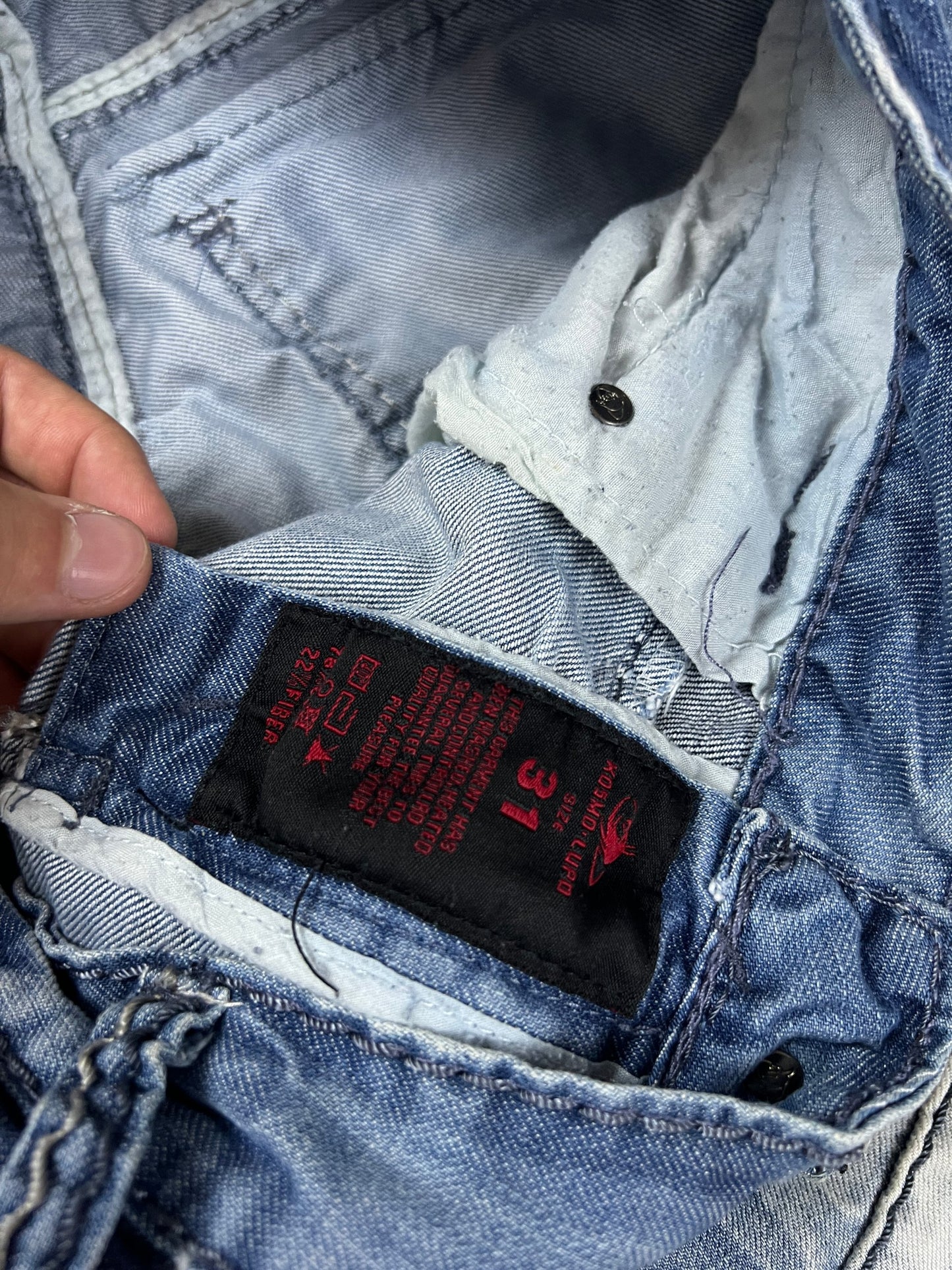 KJM blue denim jeans with white embroidered lion and logo, patchwork stitch detailing.