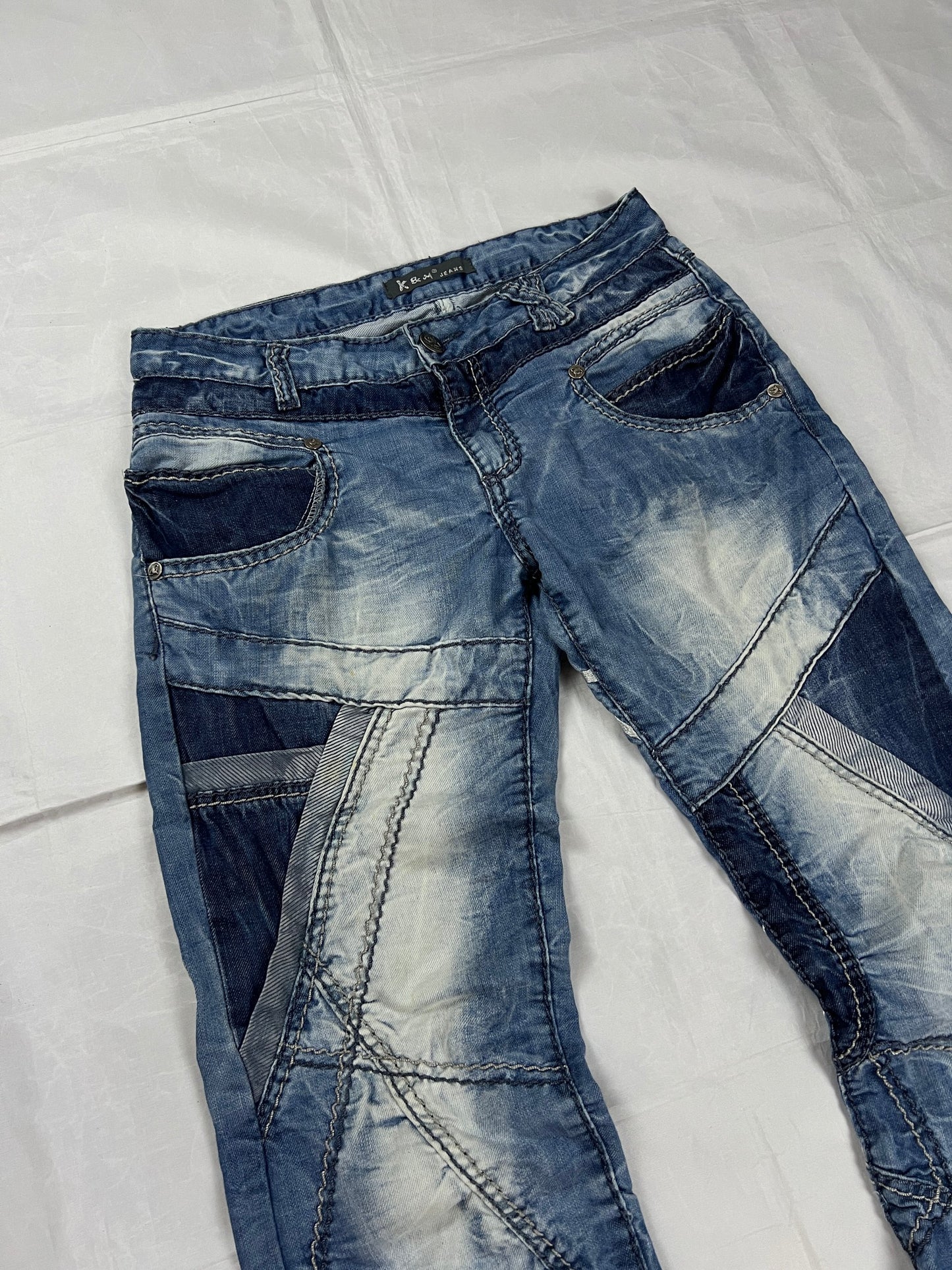 KJM blue denim jeans with white embroidered lion and logo, patchwork stitch detailing.