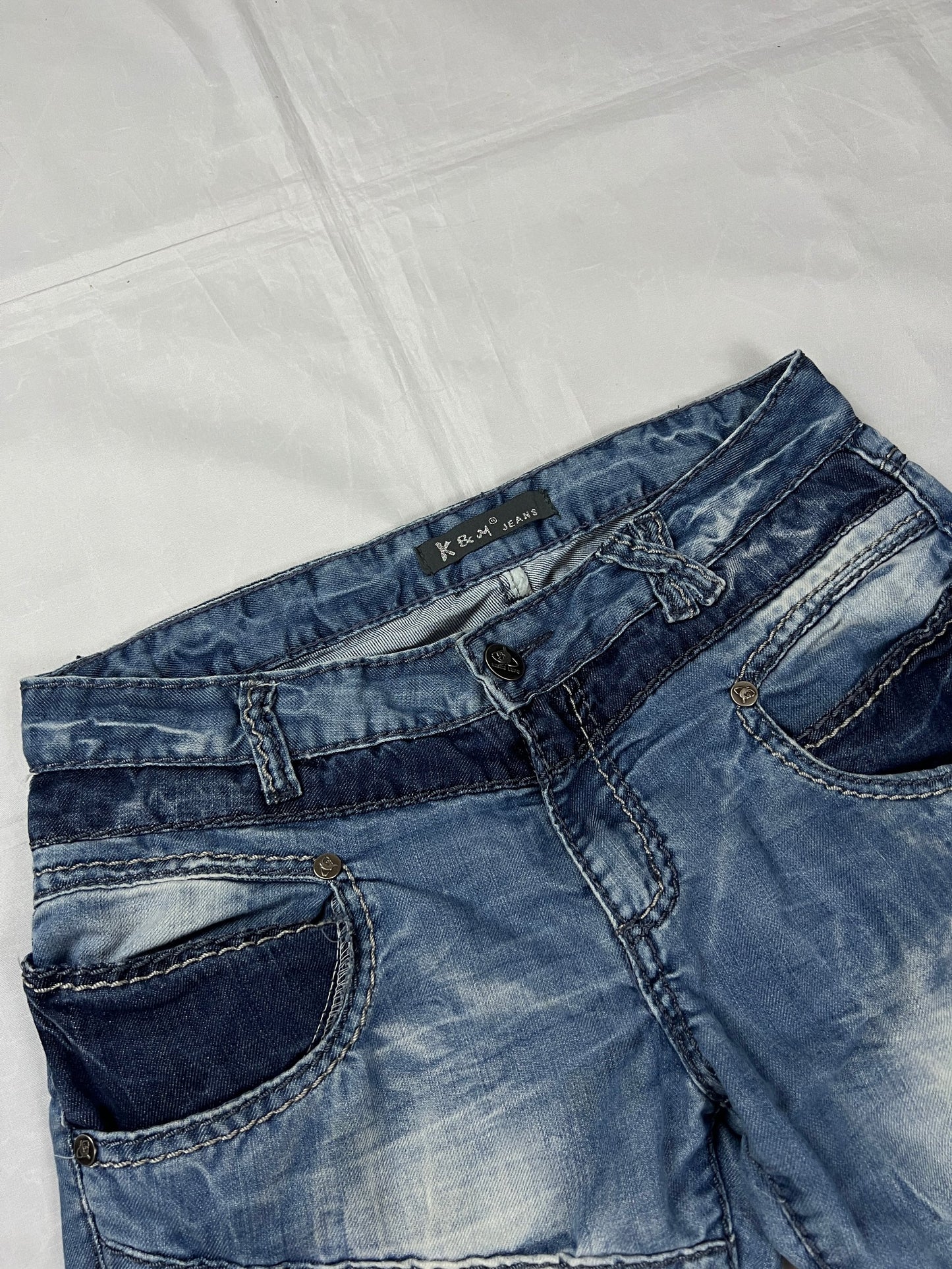 KJM blue denim jeans with white embroidered lion and logo, patchwork stitch detailing.