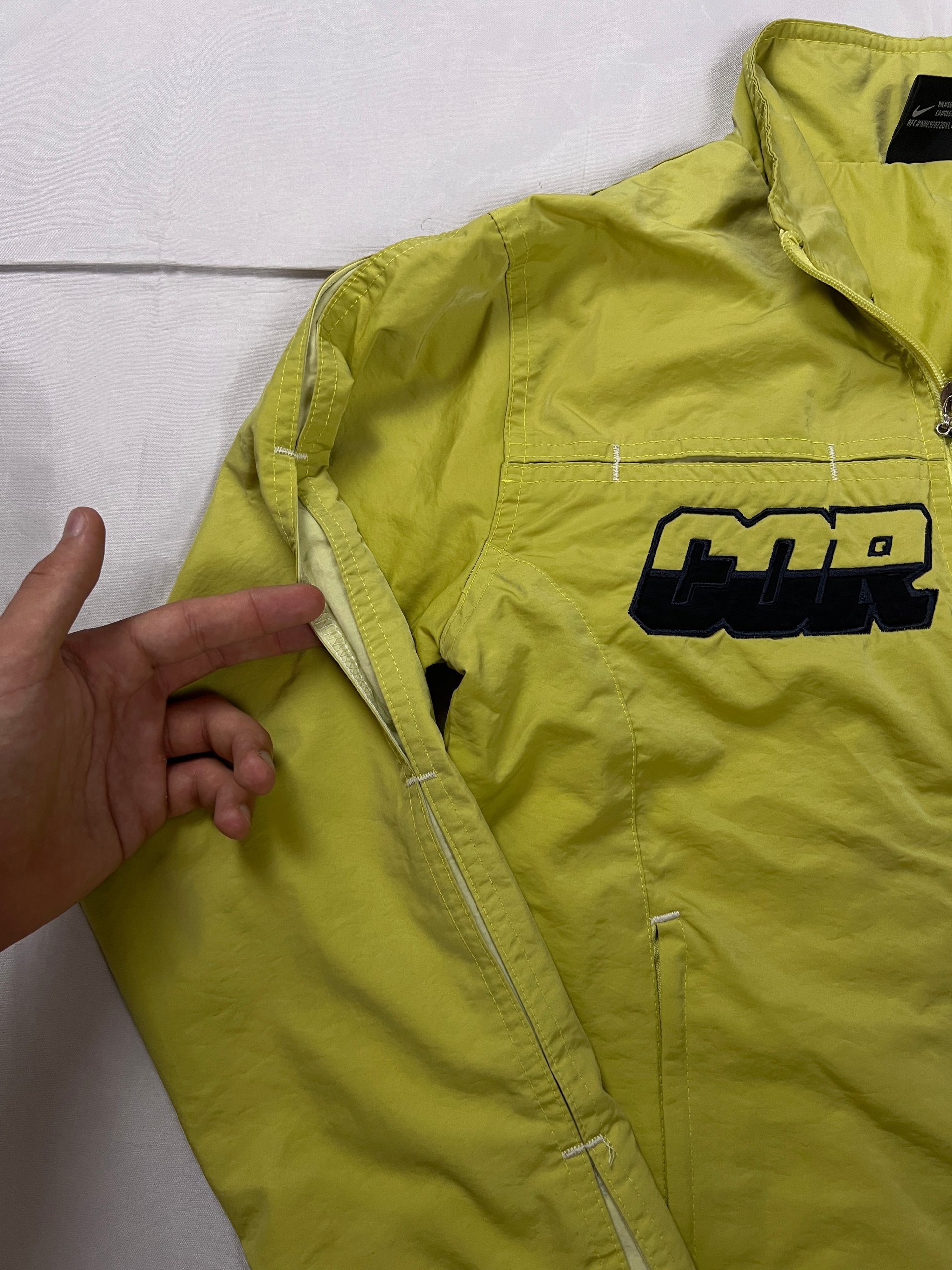 Nike yellow track jacket lightweight nylon with bold embroidered logos and sleeve zipper vent.