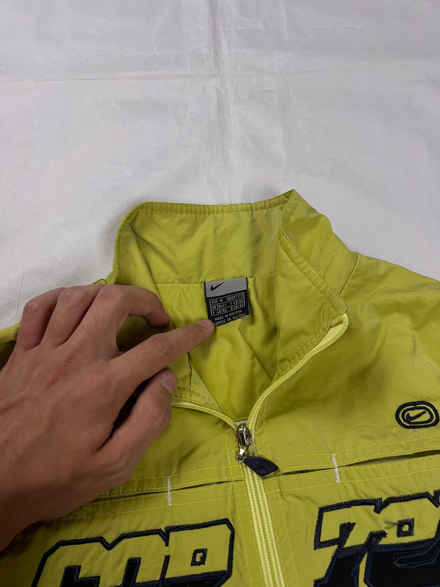Nike yellow track jacket lightweight nylon with bold embroidered logos and sleeve zipper vent.
