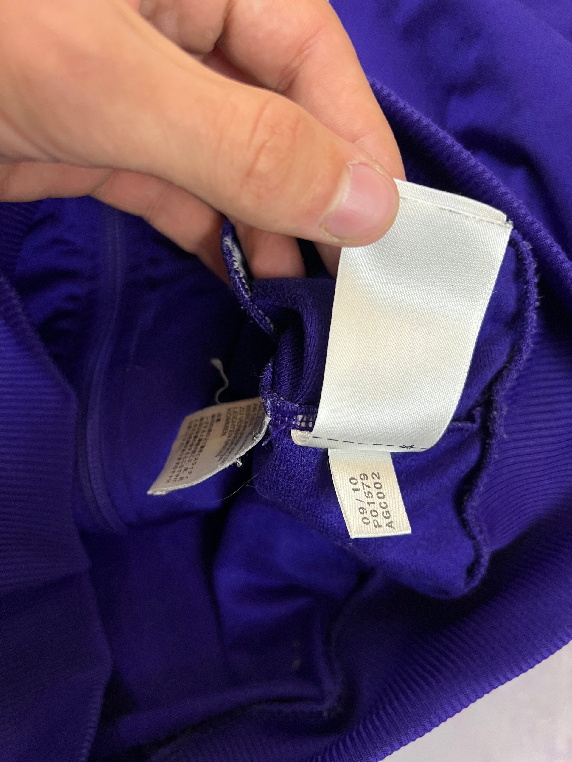 Adidas men's purple track jacket with embroidered logo and white stripes on sleeves.
