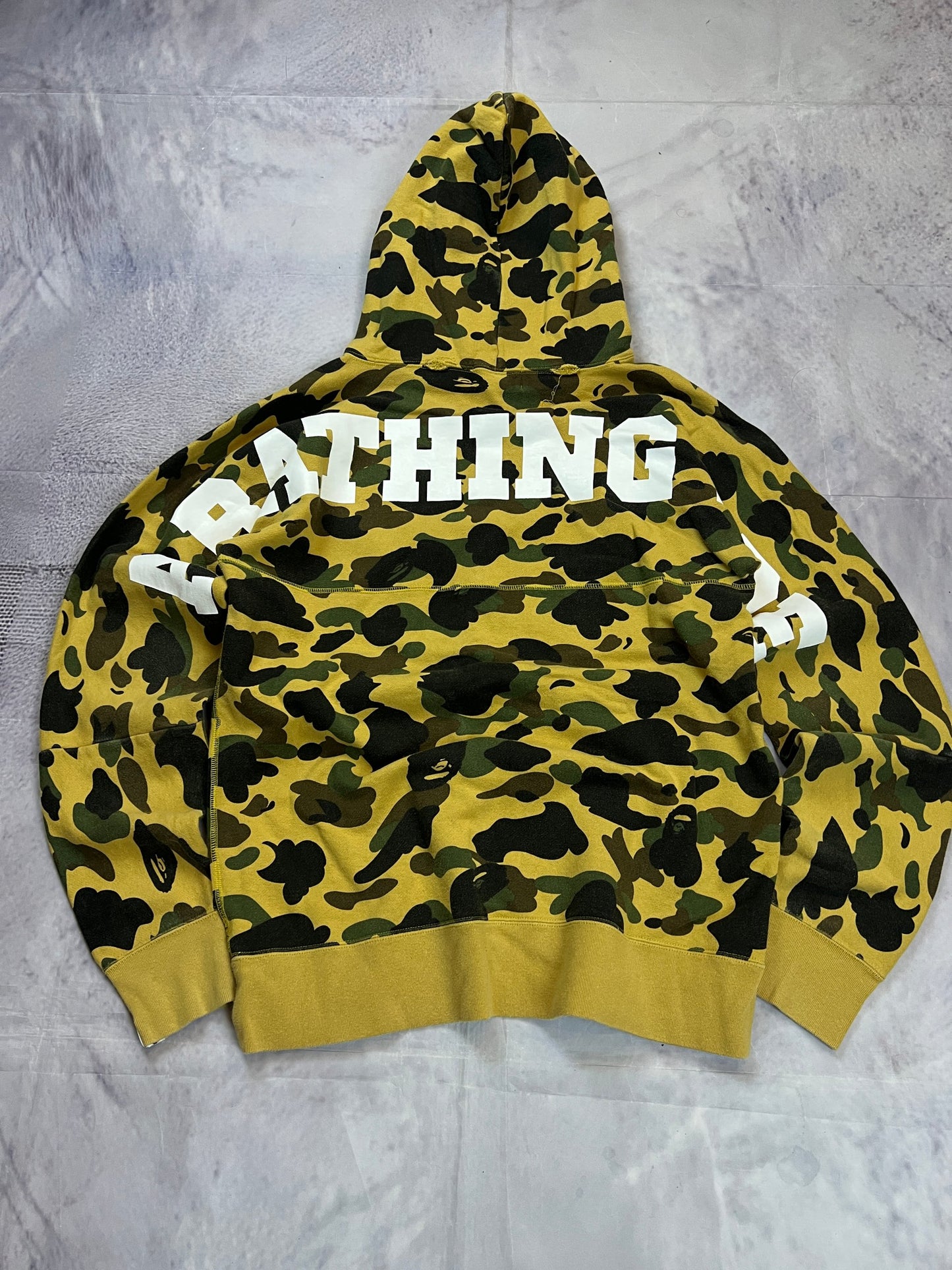 A Bathing Ape black hoodie yellow and green camo pattern with white ape head logo.