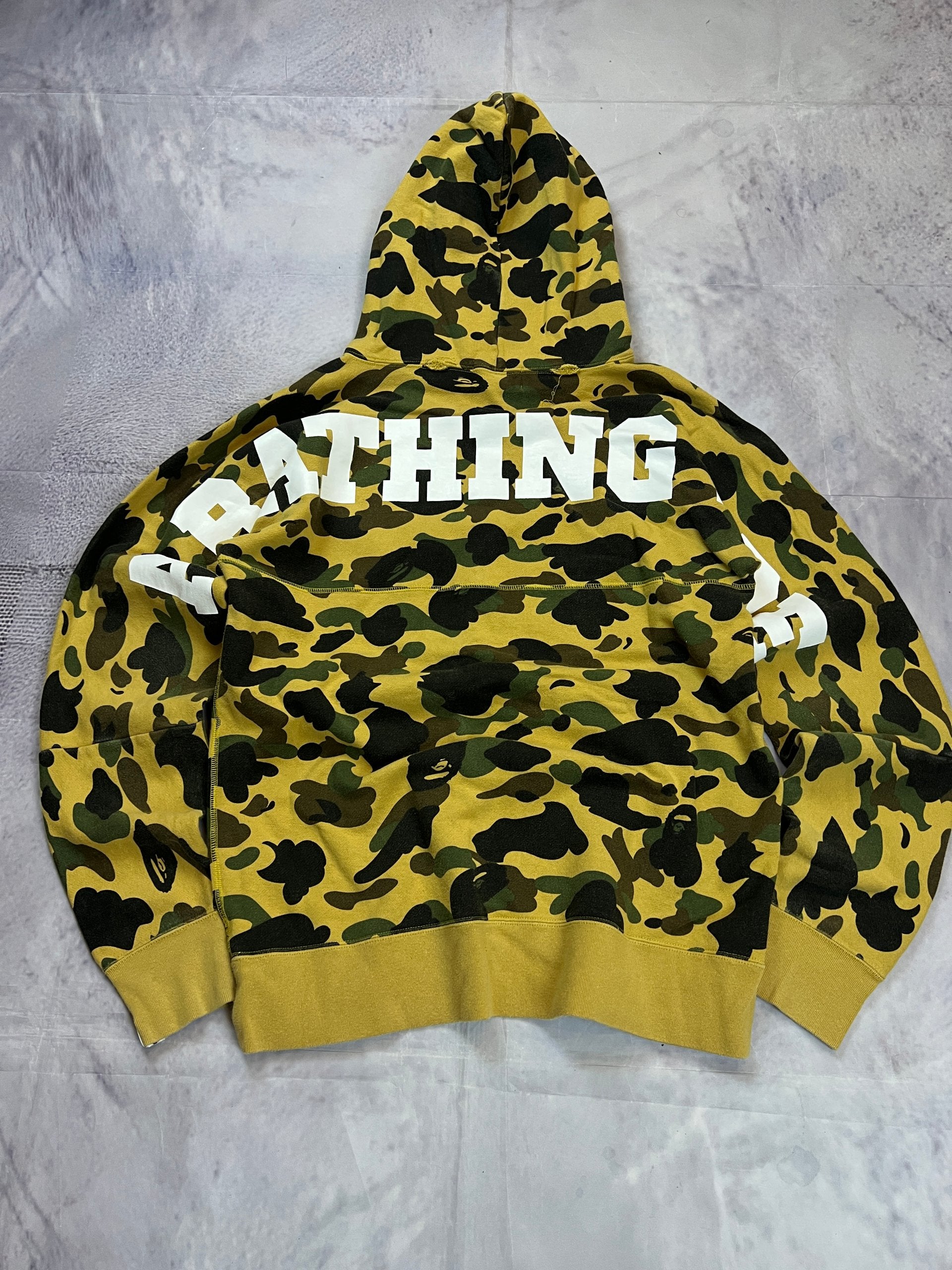 A Bathing Ape black hoodie yellow and green camo pattern with white ape head logo.