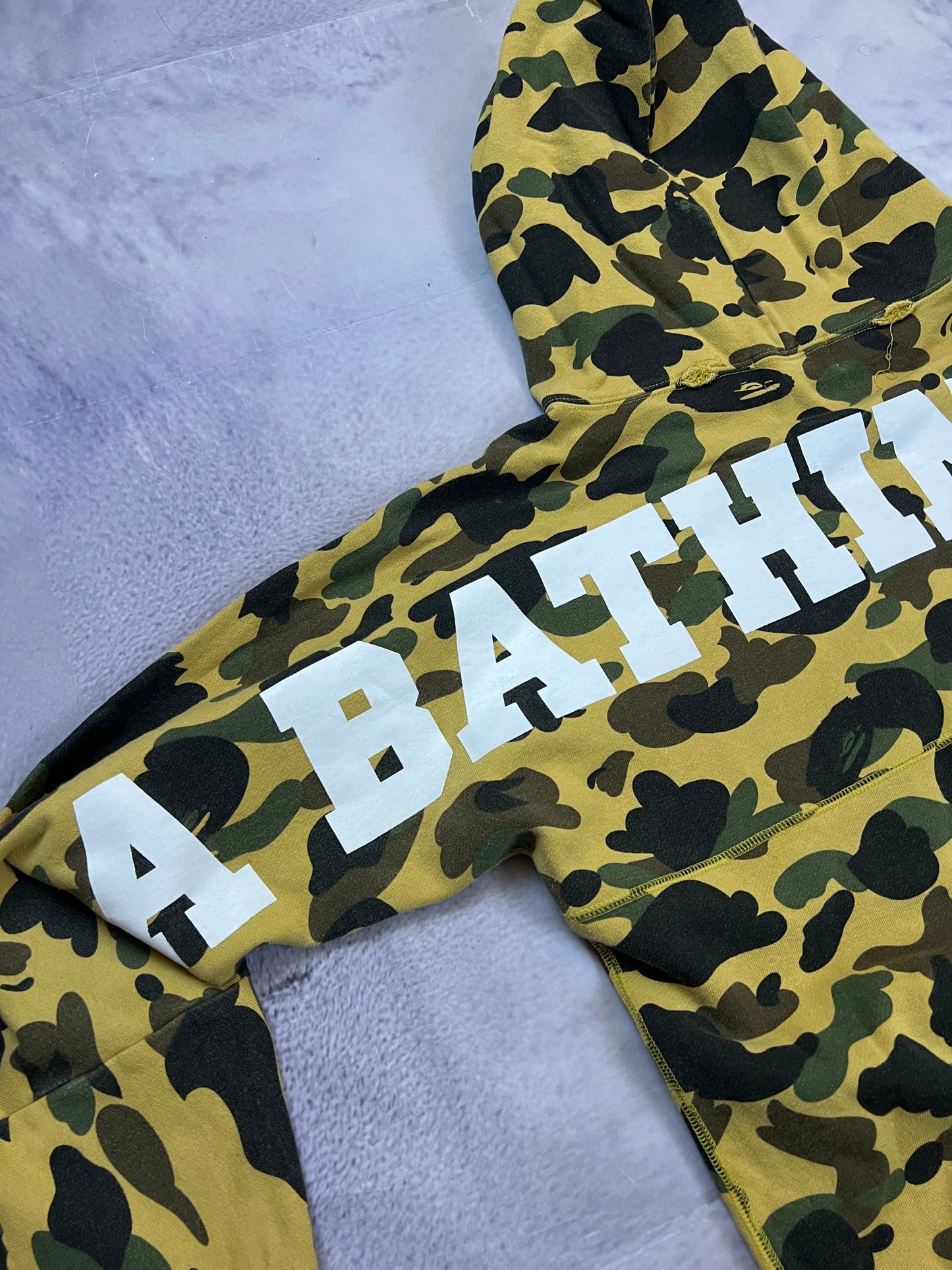 A Bathing Ape black hoodie yellow and green camo pattern with white ape head logo.