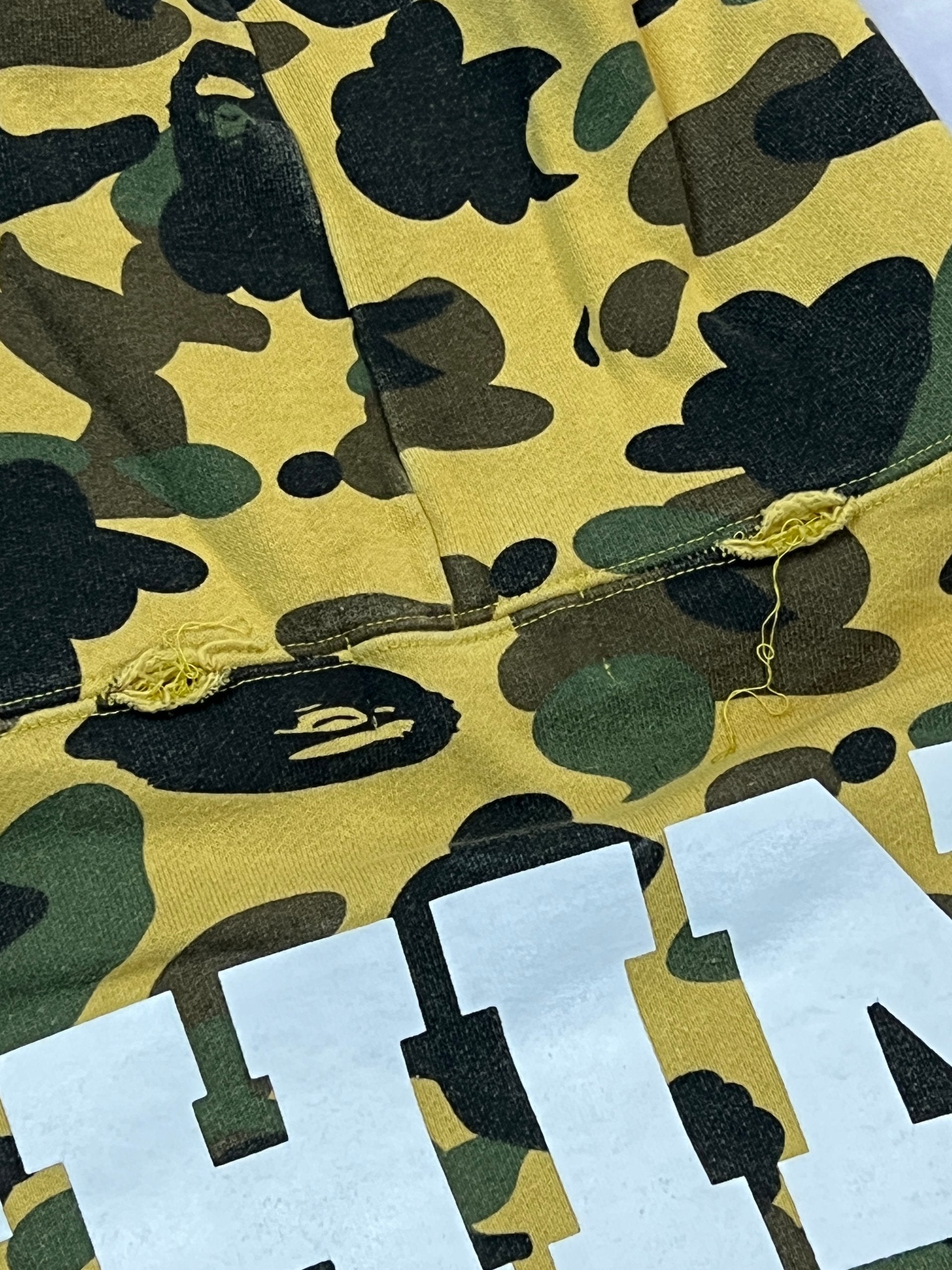 A Bathing Ape black hoodie yellow and green camo pattern with white ape head logo.