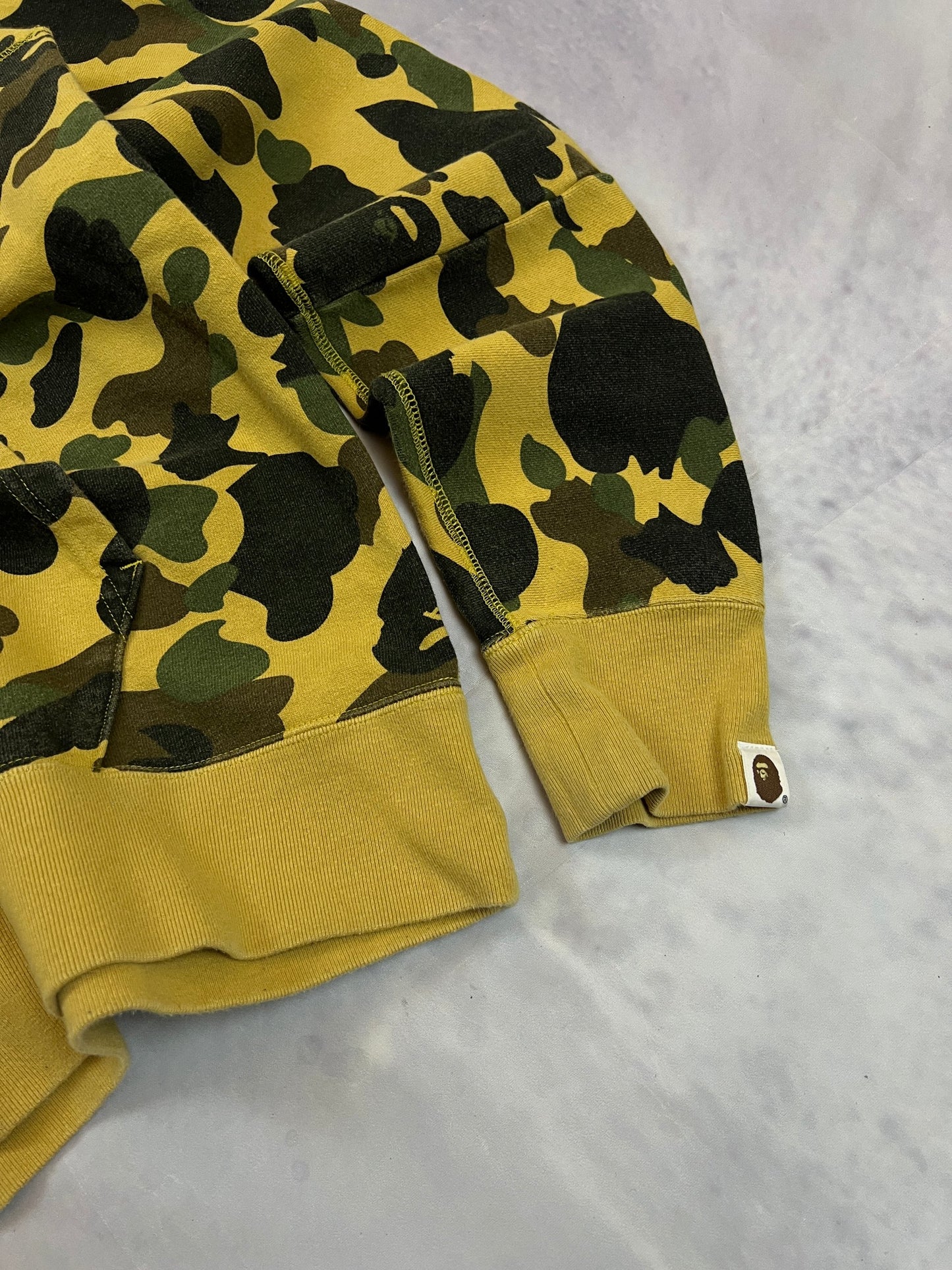 A Bathing Ape black hoodie yellow and green camo pattern with white ape head logo.