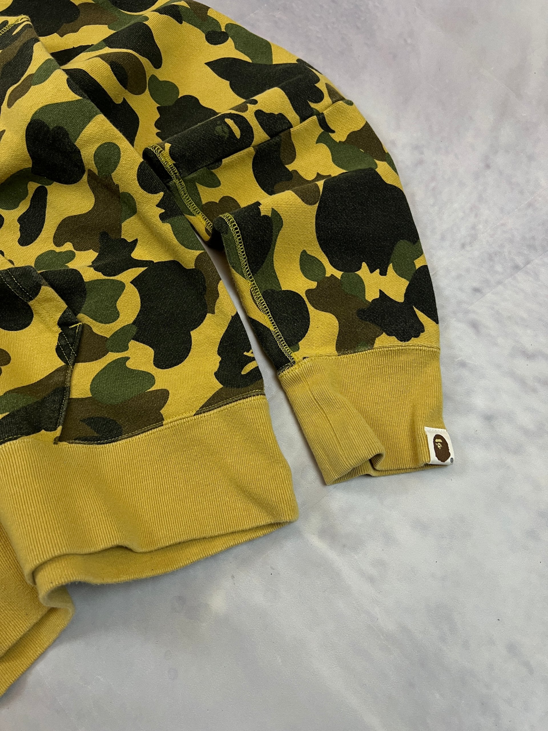 A Bathing Ape black hoodie yellow and green camo pattern with white ape head logo.