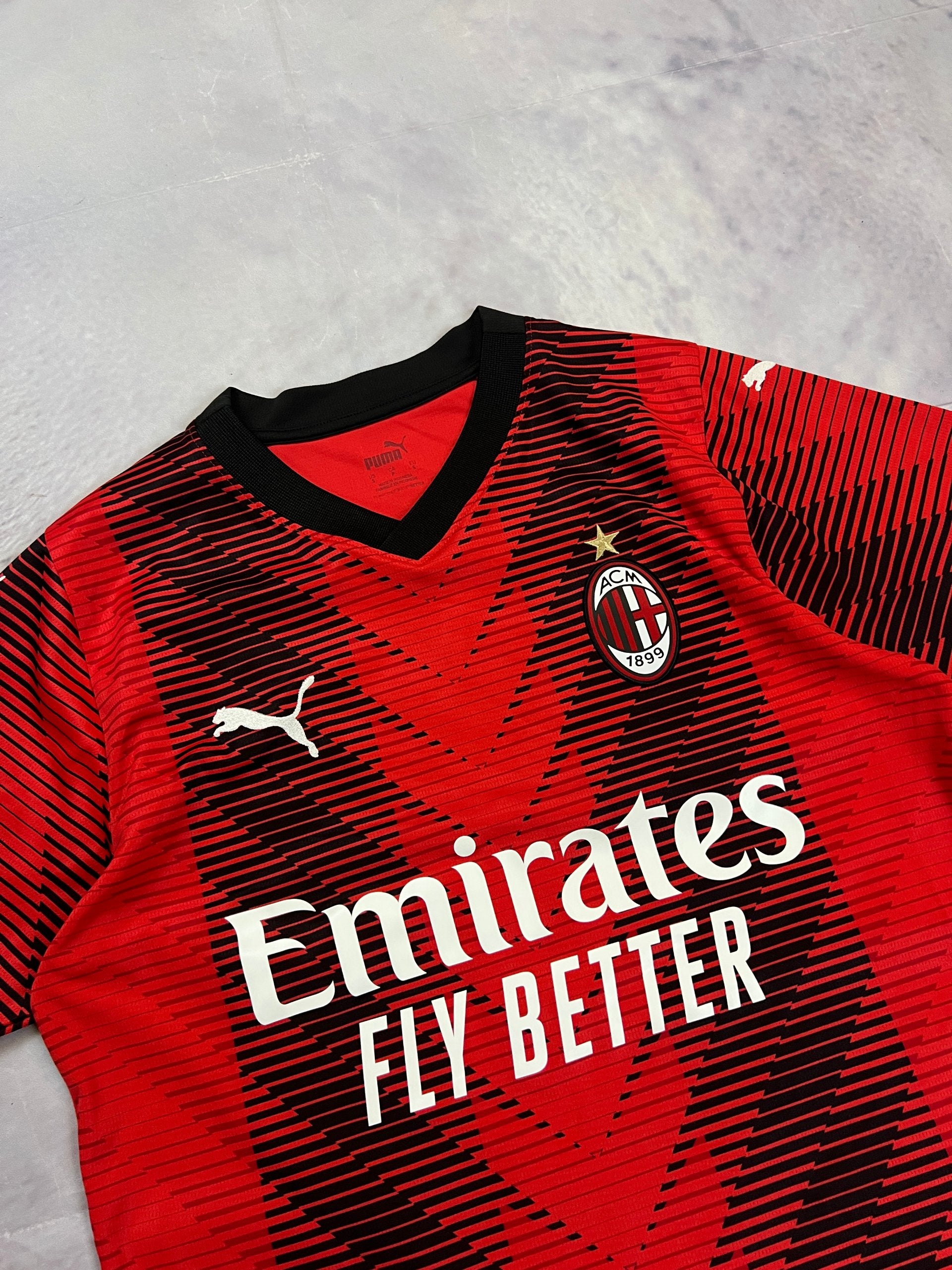 Puma AC Milan football jersey red and black, Emirates Fly Better logo, ribbed collar.