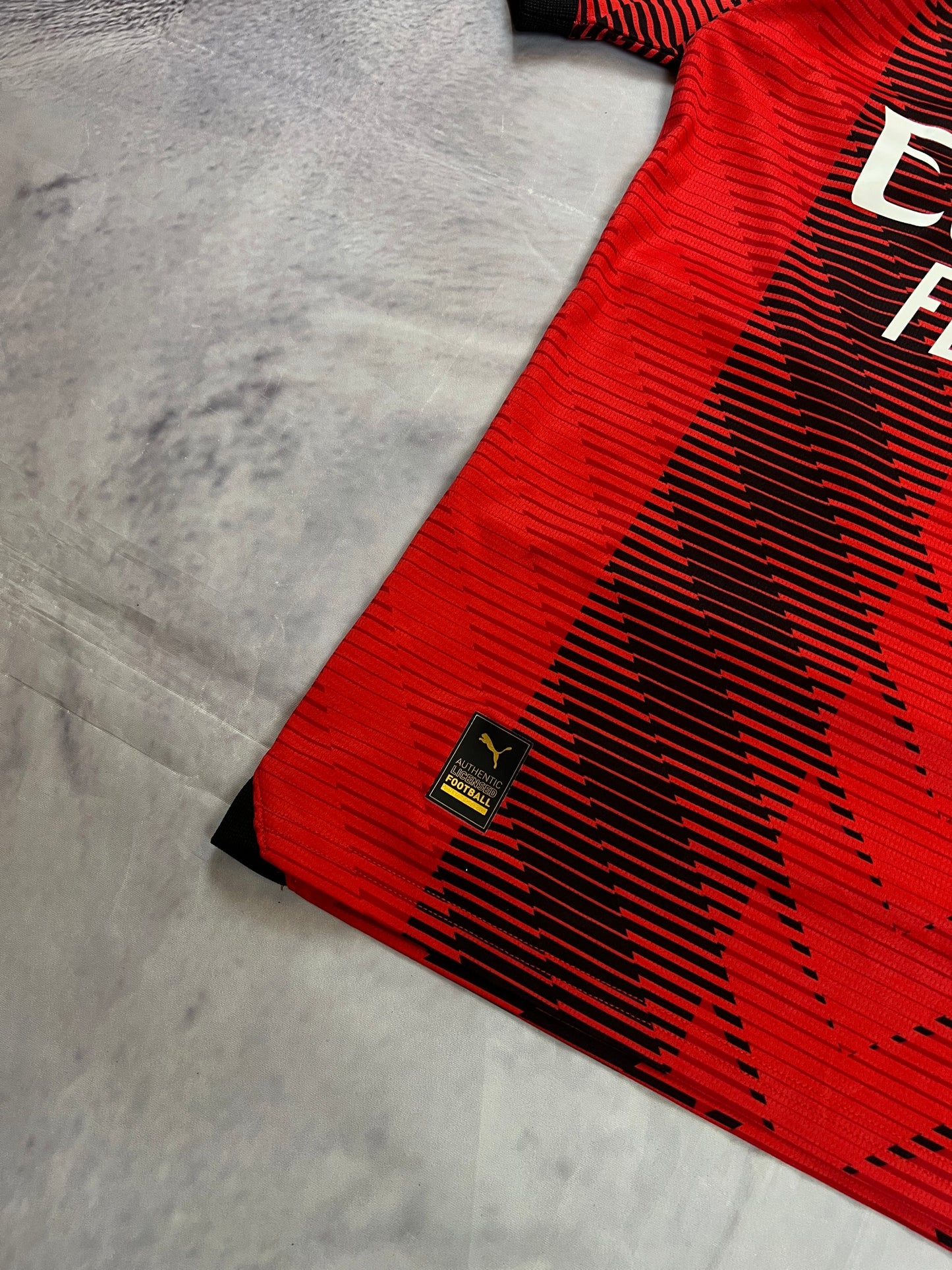 Puma AC Milan football jersey red and black, Emirates Fly Better logo, ribbed collar.