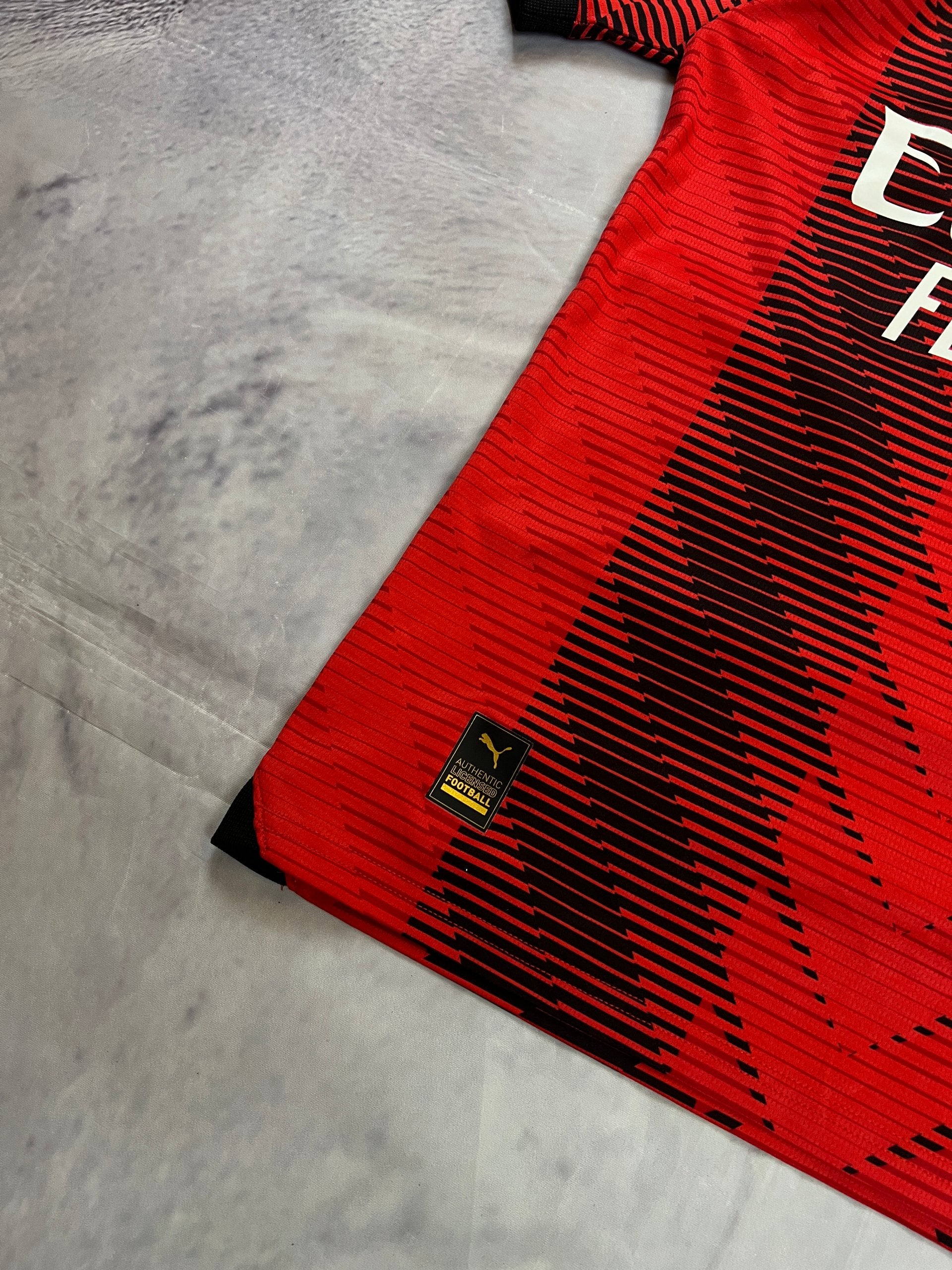 Puma AC Milan football jersey red and black, Emirates Fly Better logo, ribbed collar.