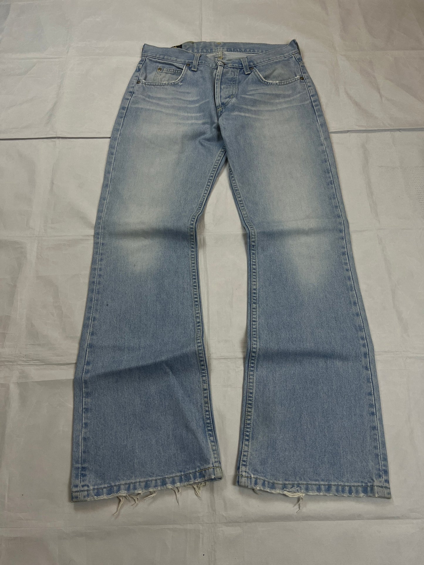 Lee light blue flared jeans with leather patch, five-pocket styling, and frayed hems.