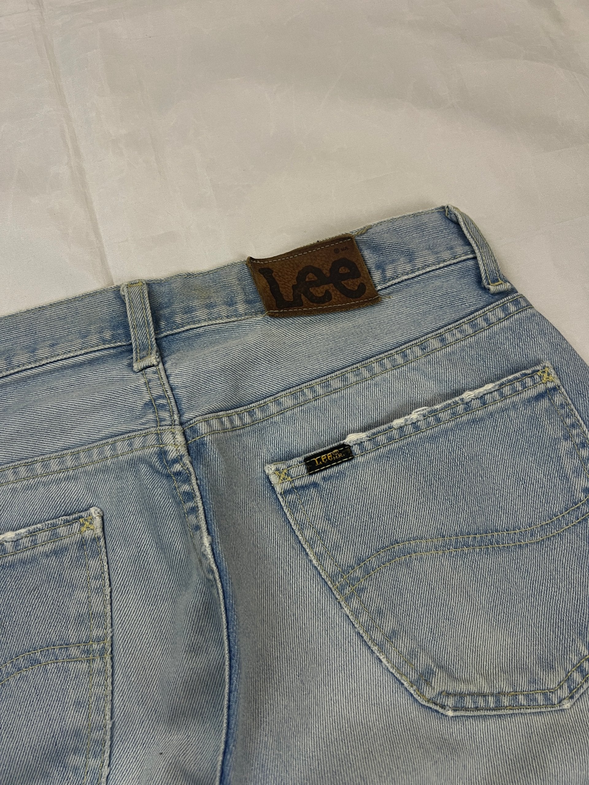 Lee light blue flared jeans with leather patch, five-pocket styling, and frayed hems.