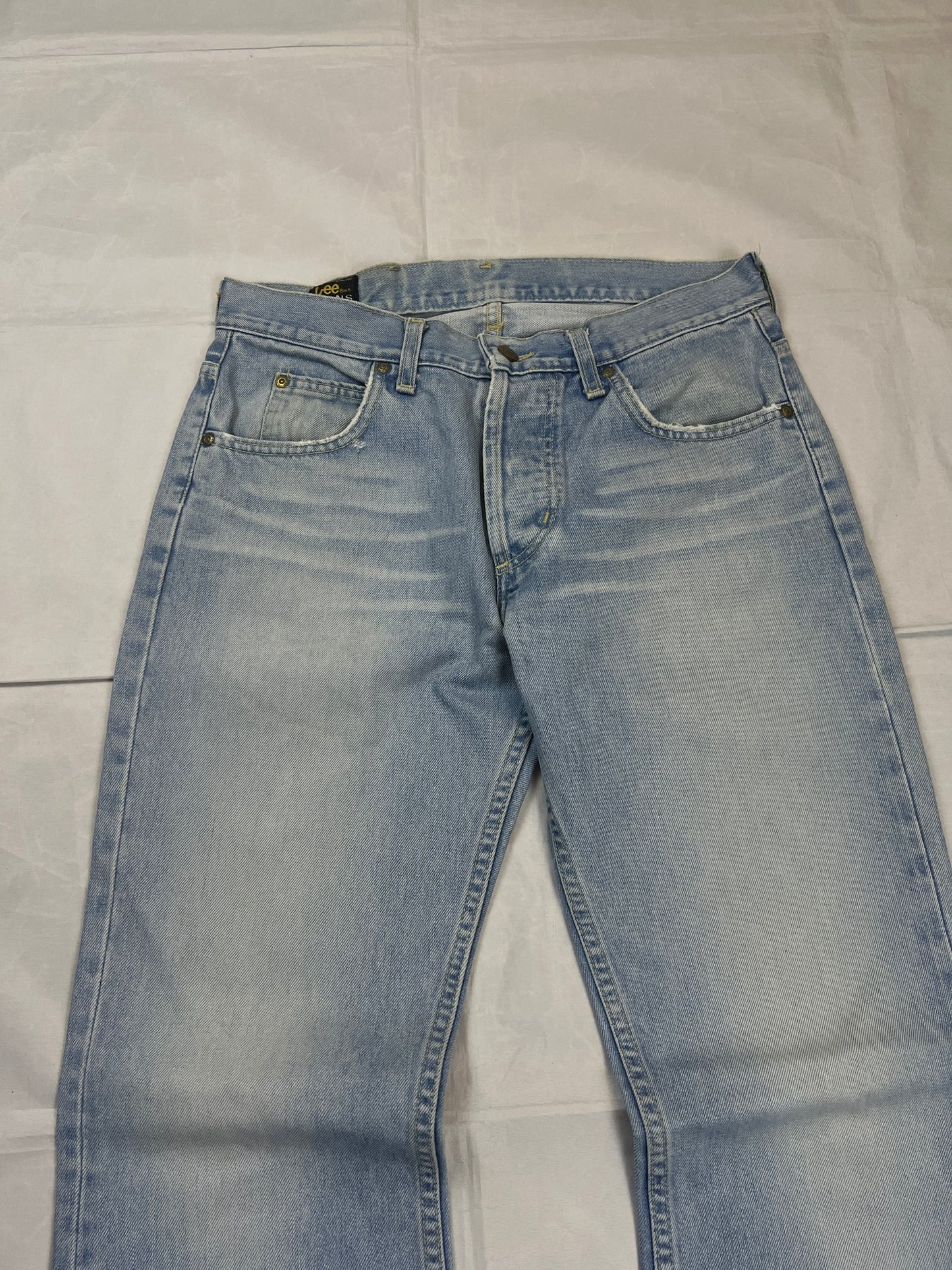 Lee light blue flared jeans with leather patch, five-pocket styling, and frayed hems.