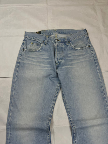 Lee light blue flared jeans with leather patch, five-pocket styling, and frayed hems.