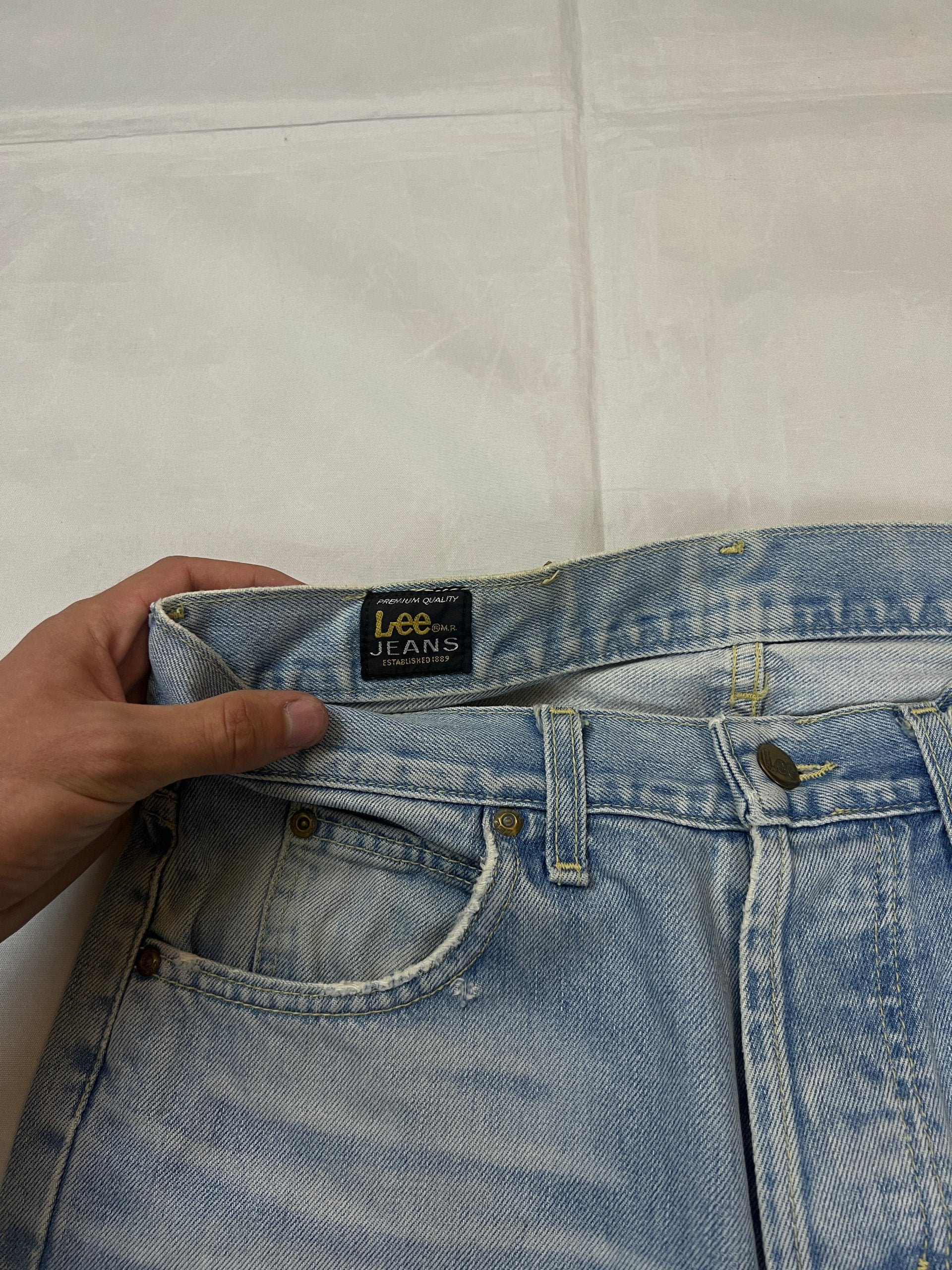 Lee light blue flared jeans with leather patch, five-pocket styling, and frayed hems.