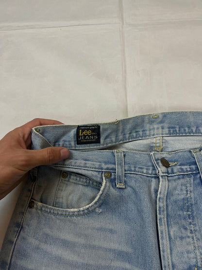 Lee light blue flared jeans with leather patch, five-pocket styling, and frayed hems.