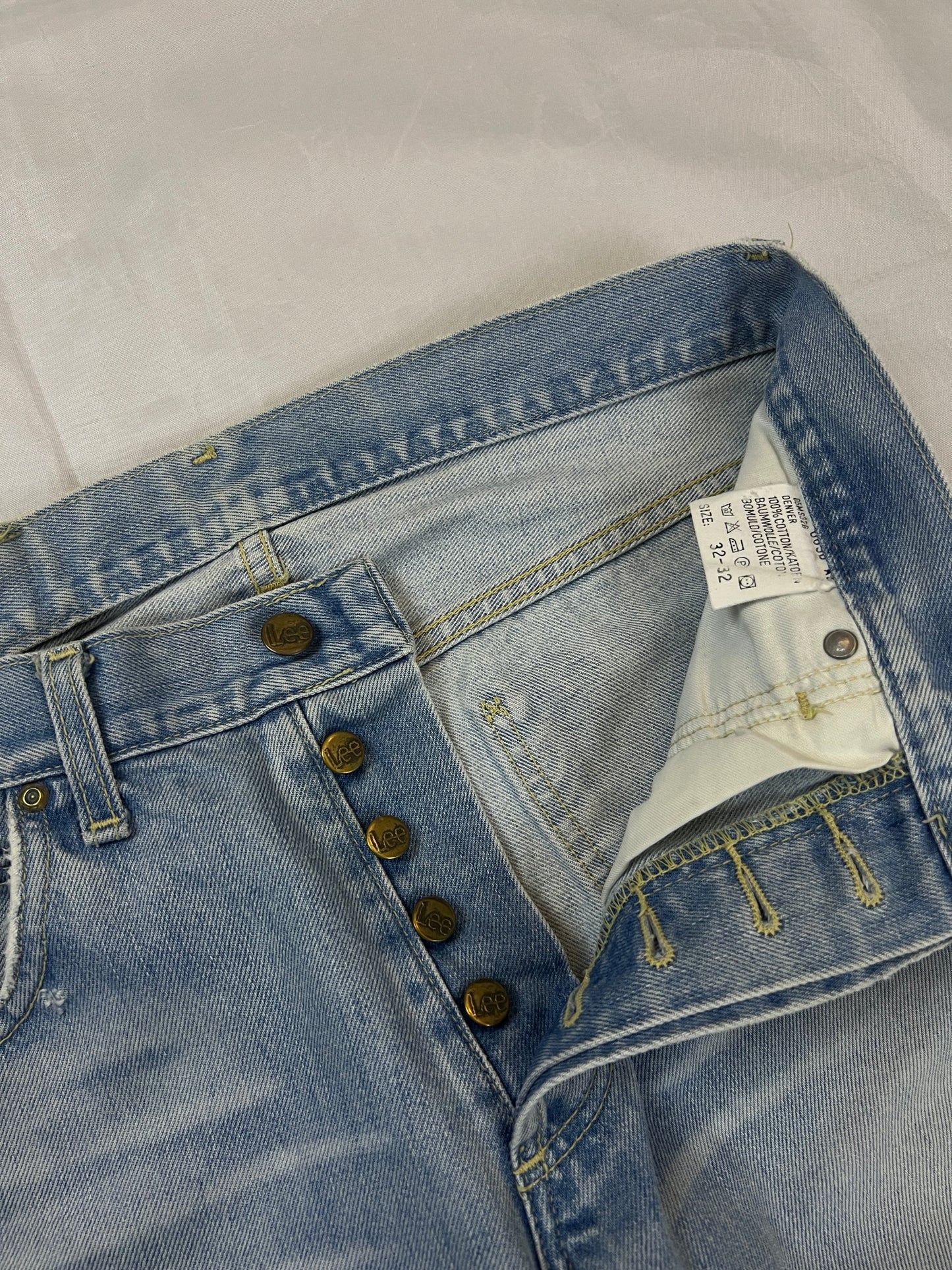 Lee light blue flared jeans with leather patch, five-pocket styling, and frayed hems.