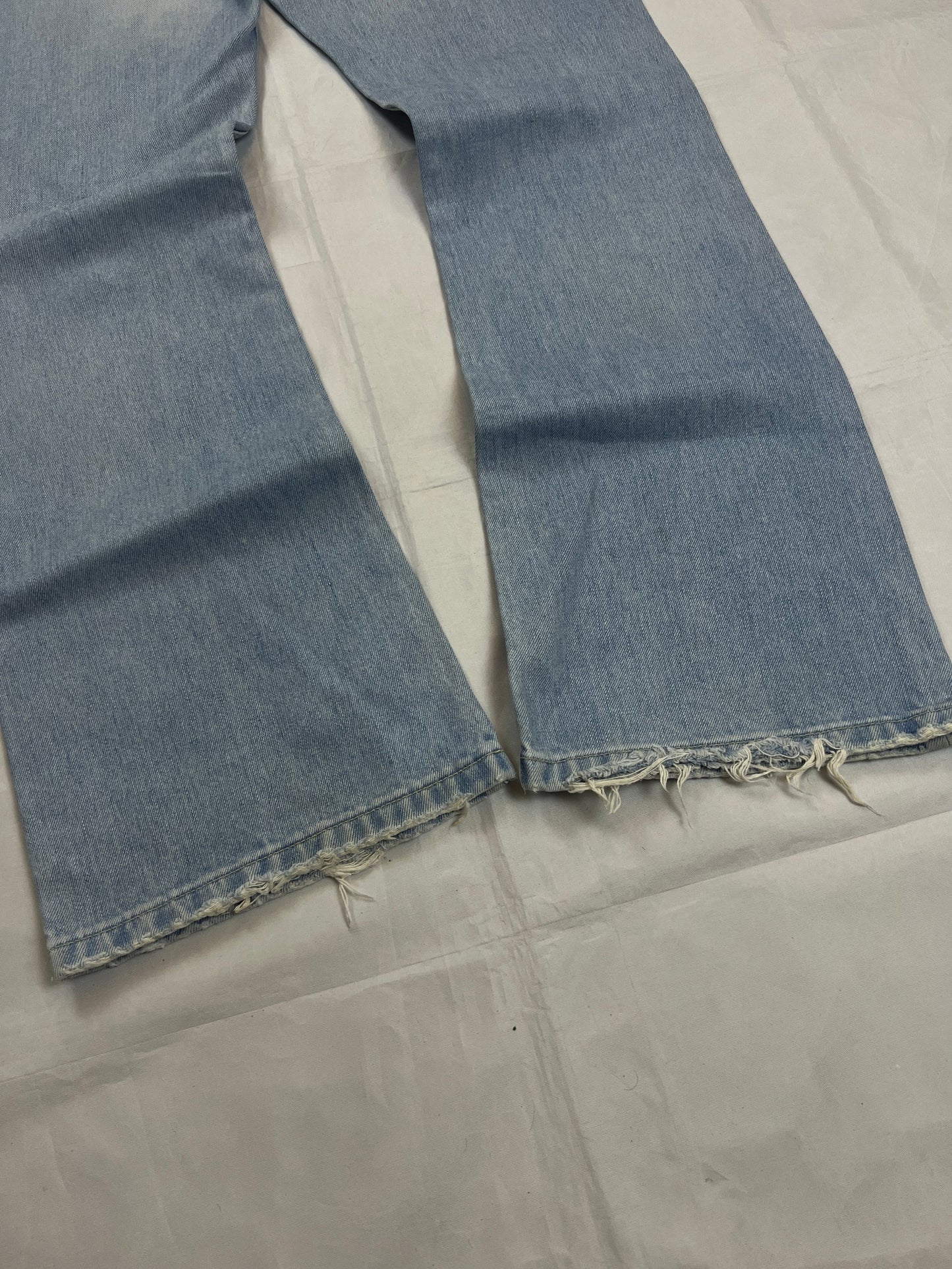 Lee light blue flared jeans with leather patch, five-pocket styling, and frayed hems.