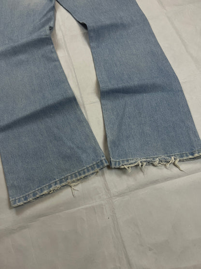 Lee light blue flared jeans with leather patch, five-pocket styling, and frayed hems.
