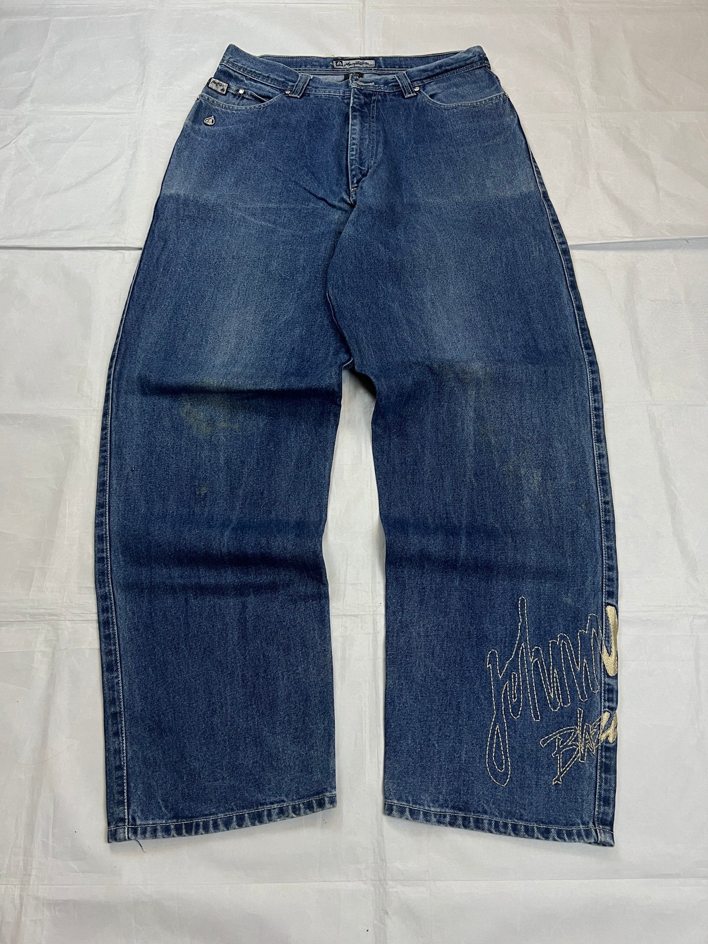Johnny Blaze blue wide leg jeans with embroidered logo and leather patch on waistband.