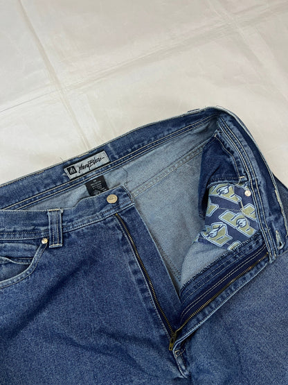 Johnny Blaze blue wide leg jeans with embroidered logo and leather patch on waistband.