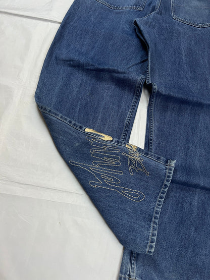 Johnny Blaze blue wide leg jeans with embroidered logo and leather patch on waistband.