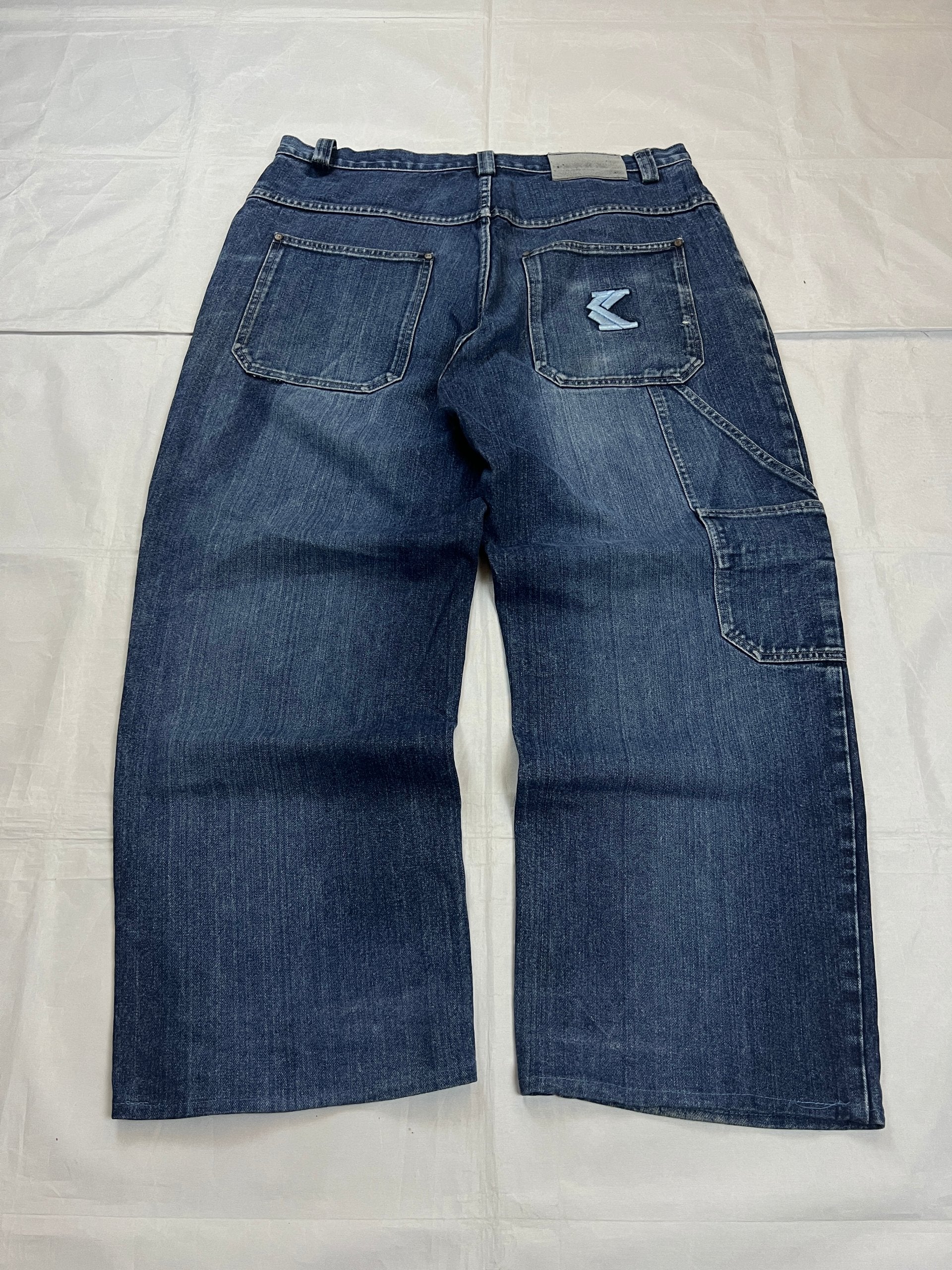 Kani blue denim carpenter jeans with distressed details, faded wash, and patch pockets.
