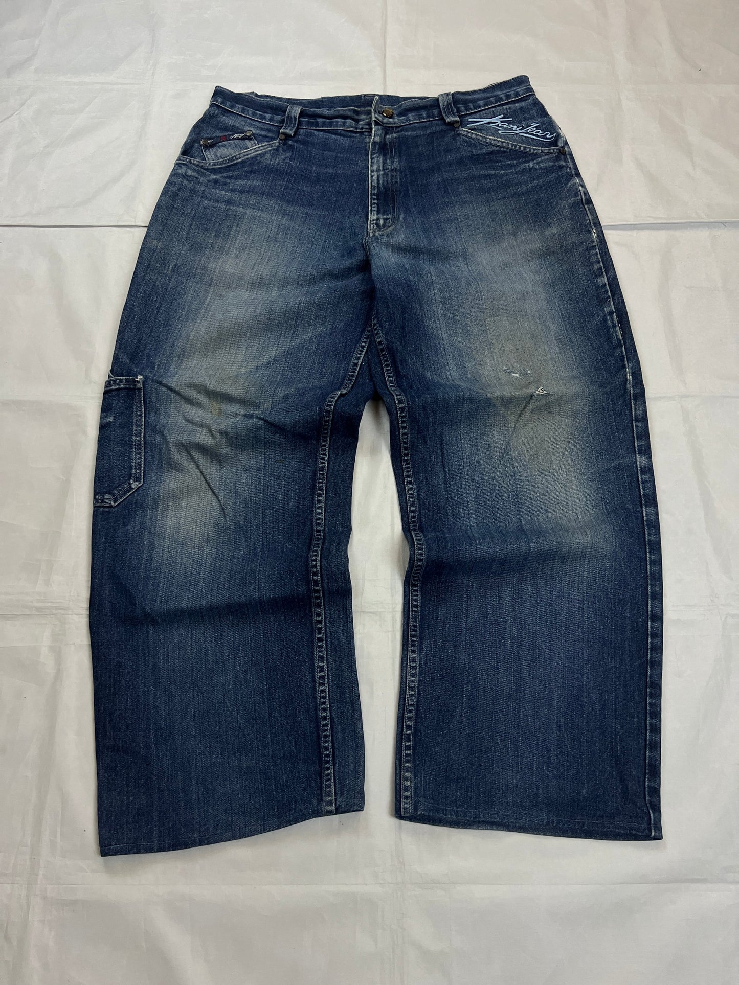Kani blue denim carpenter jeans with distressed details, faded wash, and patch pockets.