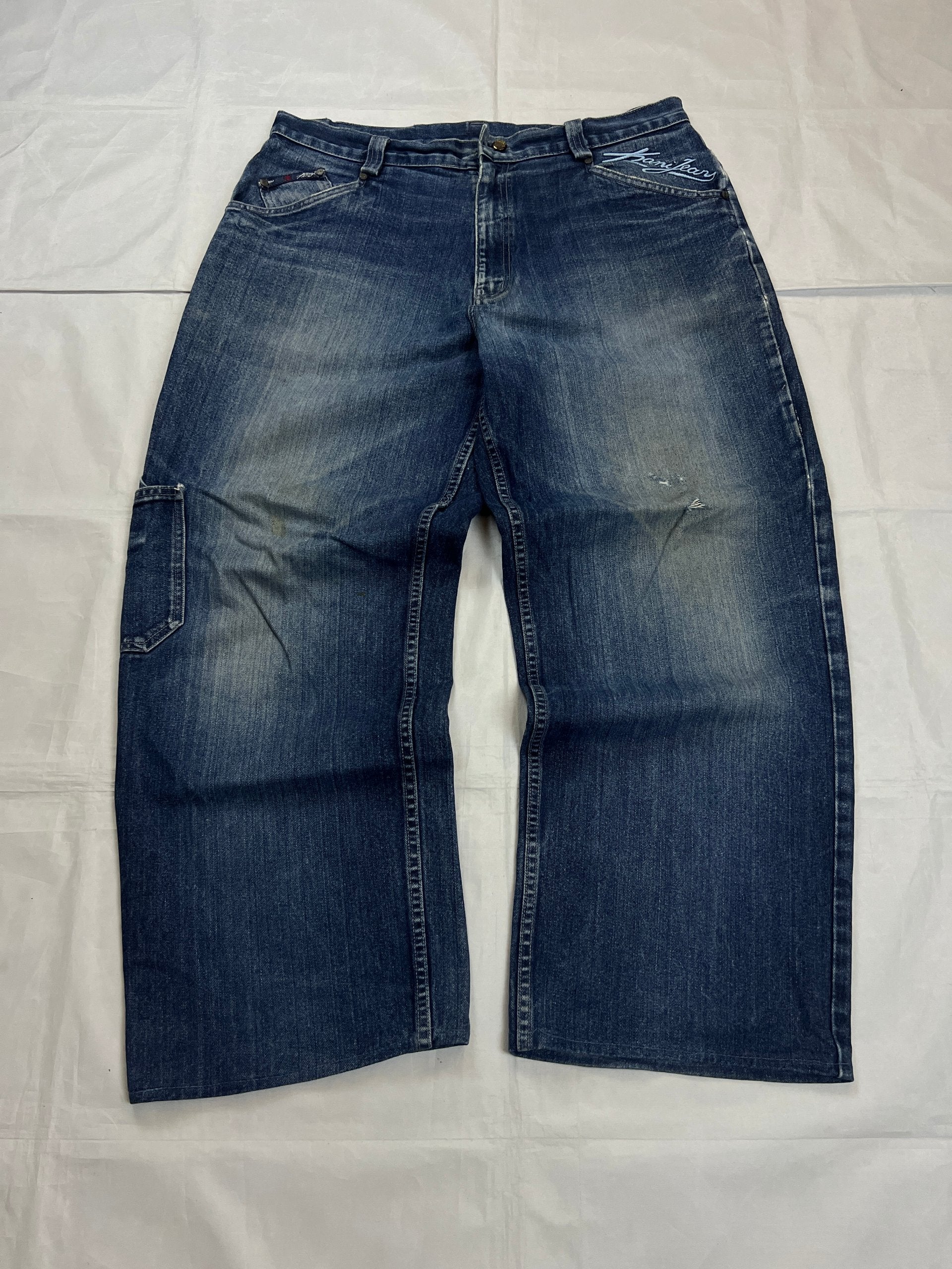Kani blue denim carpenter jeans with distressed details, faded wash, and patch pockets.