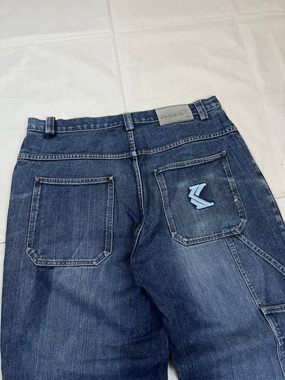 Kani blue denim carpenter jeans with distressed details, faded wash, and patch pockets.