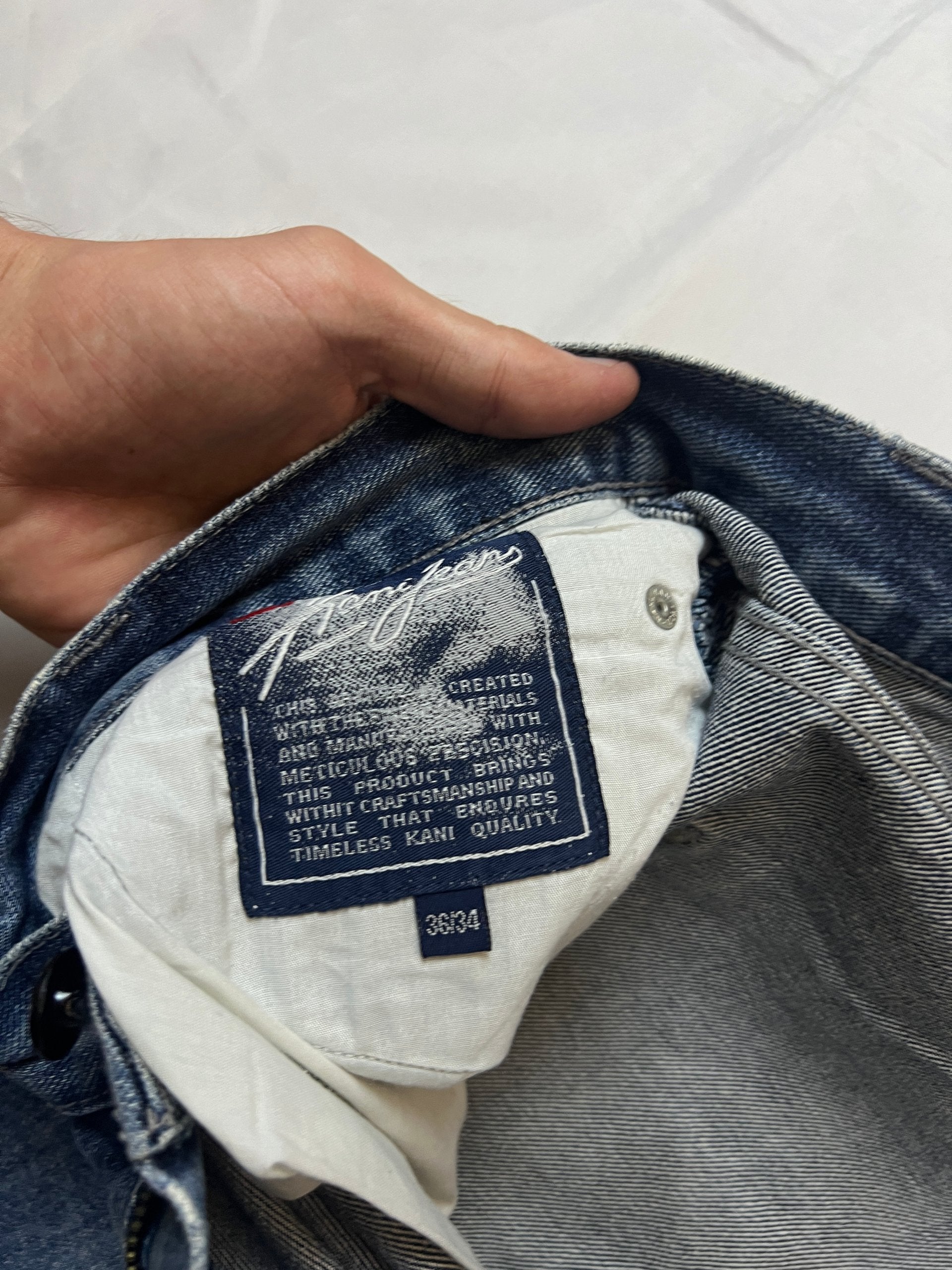 Kani blue denim carpenter jeans with distressed details, faded wash, and patch pockets.
