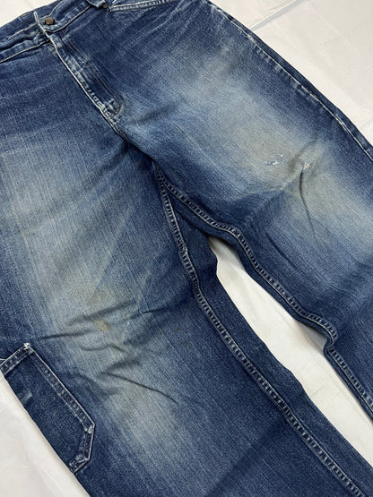 Kani blue denim carpenter jeans with distressed details, faded wash, and patch pockets.