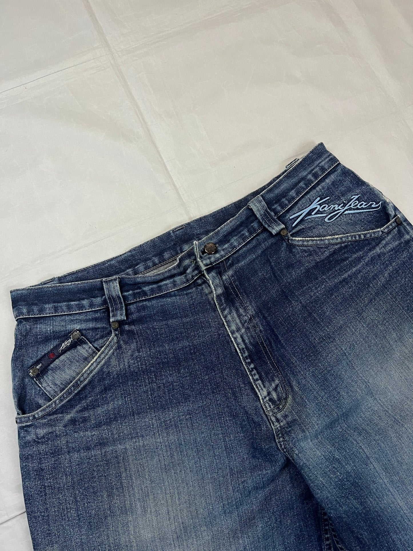 Kani blue denim carpenter jeans with distressed details, faded wash, and patch pockets.