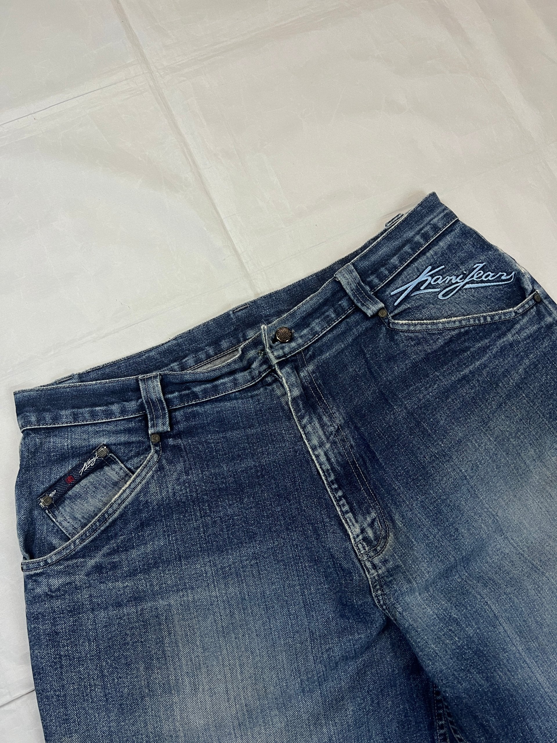 Kani blue denim carpenter jeans with distressed details, faded wash, and patch pockets.