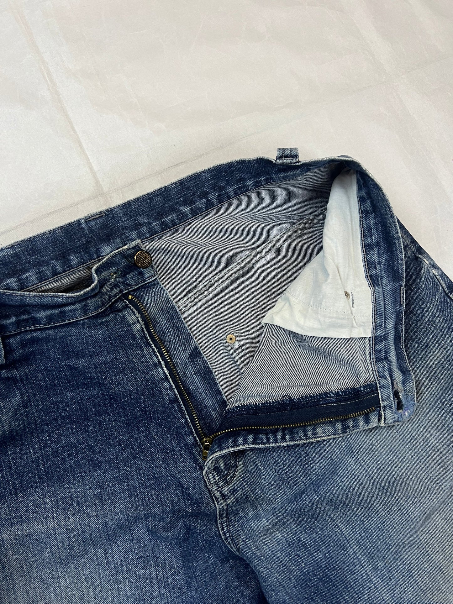 Kani blue denim carpenter jeans with distressed details, faded wash, and patch pockets.