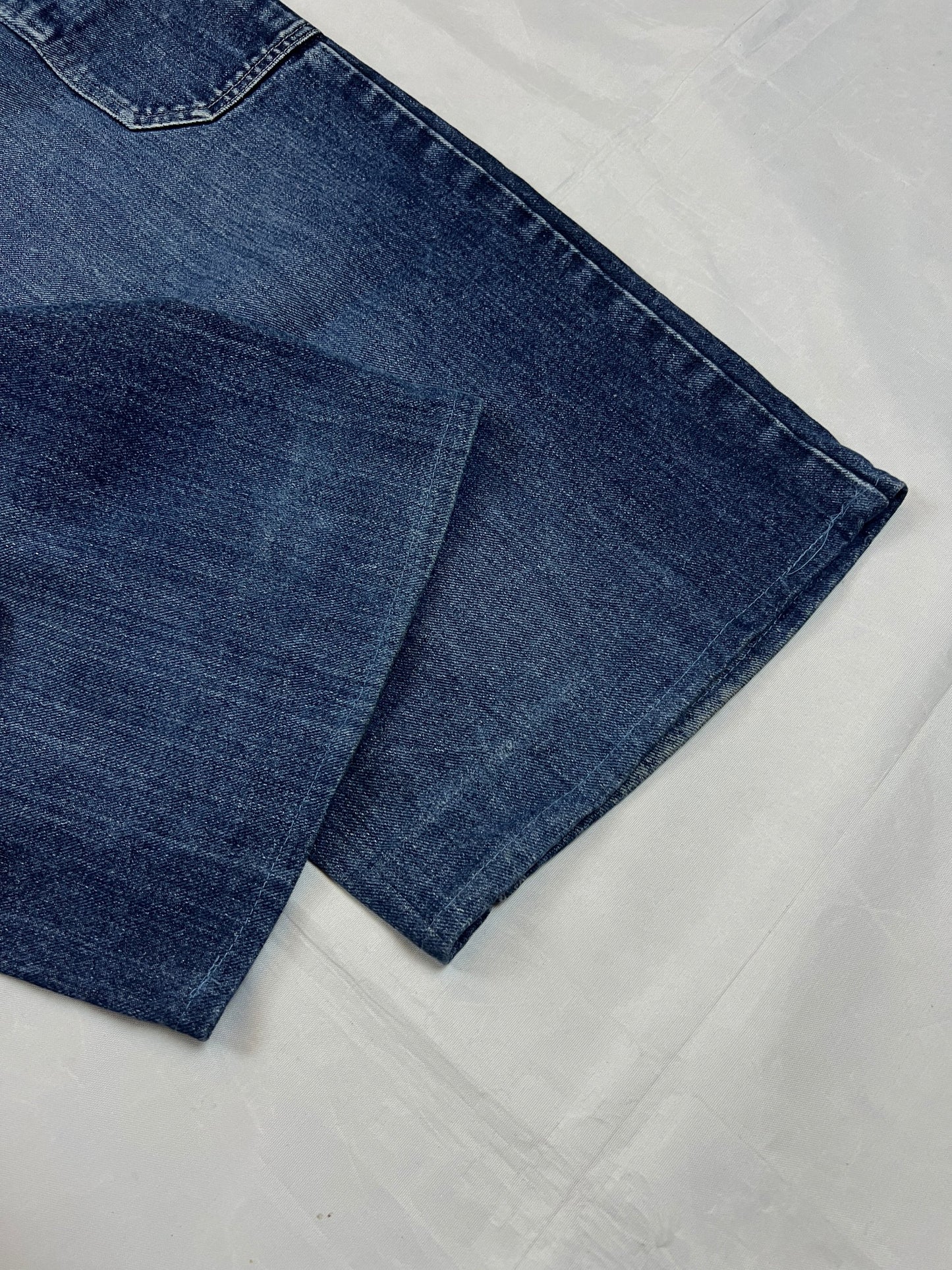 Kani blue denim carpenter jeans with distressed details, faded wash, and patch pockets.