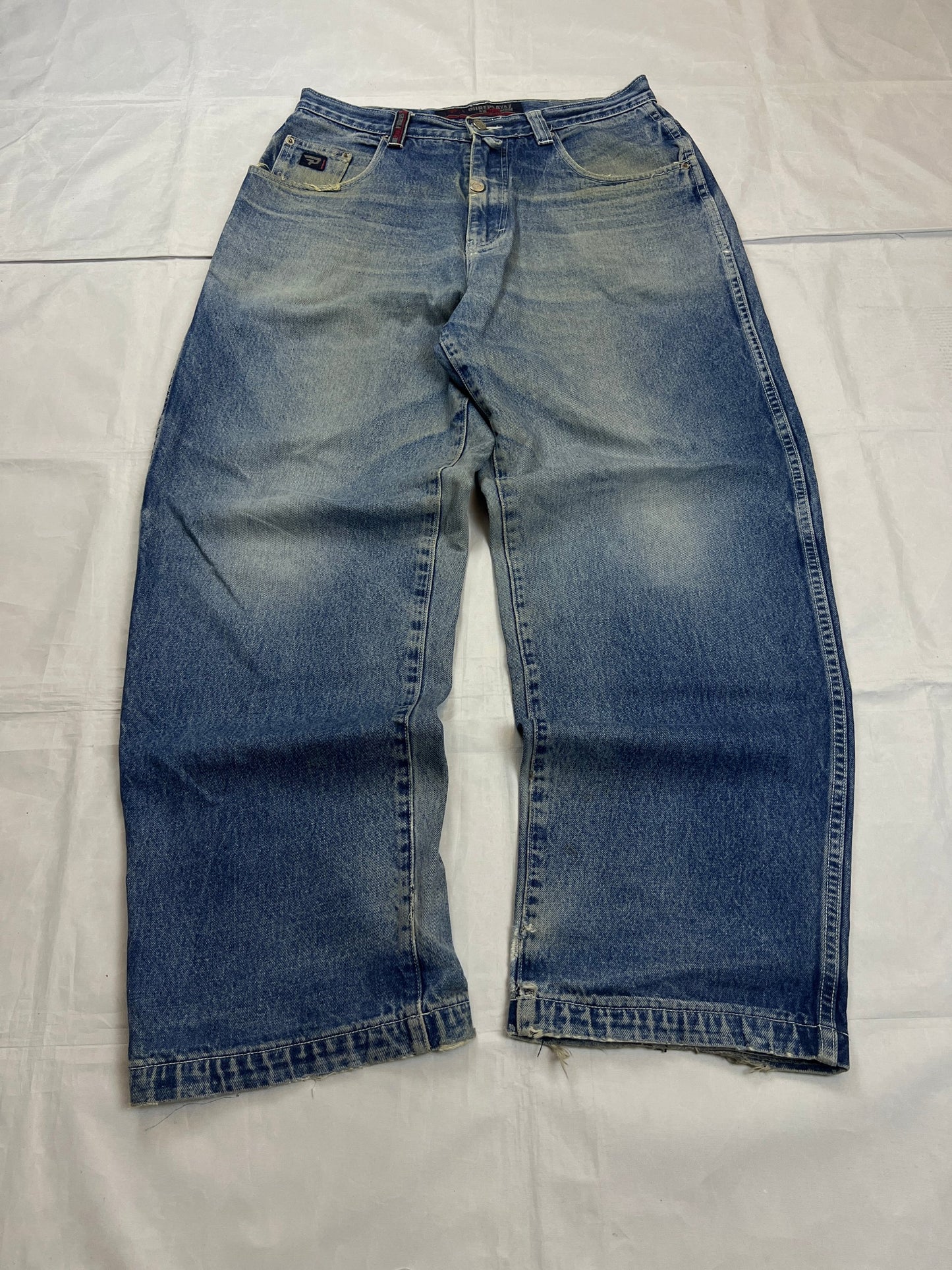 Pure Playaz blue denim jeans with distressed rips, faded wash, and branded patches.