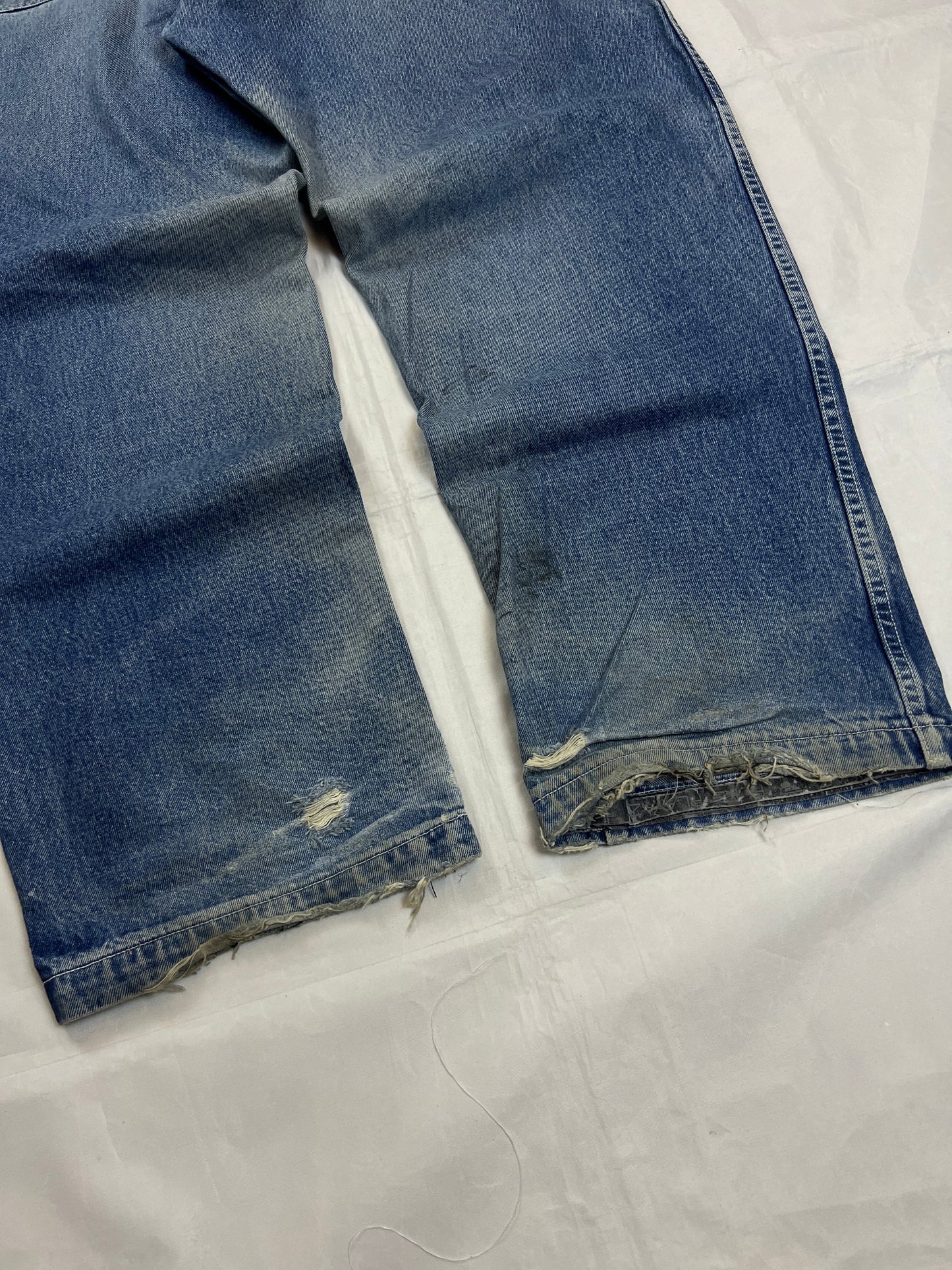 Pure Playaz blue denim jeans with distressed rips, faded wash, and branded patches.