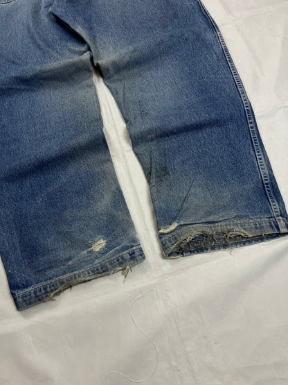 Pure Playaz blue denim jeans with distressed rips, faded wash, and branded patches.