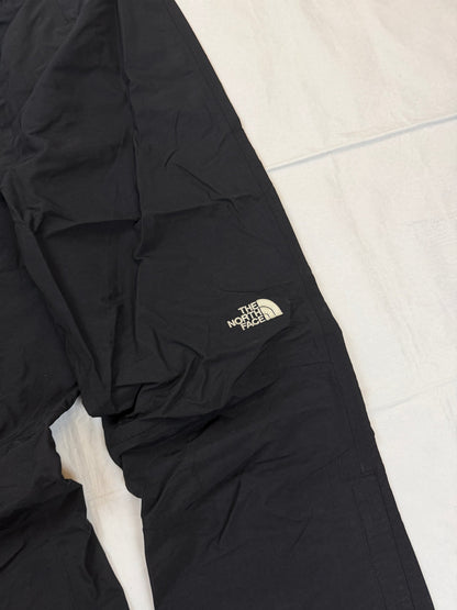 The North Face black hiking trousers with embroidered logo and adjustable Velcro ankle closures.