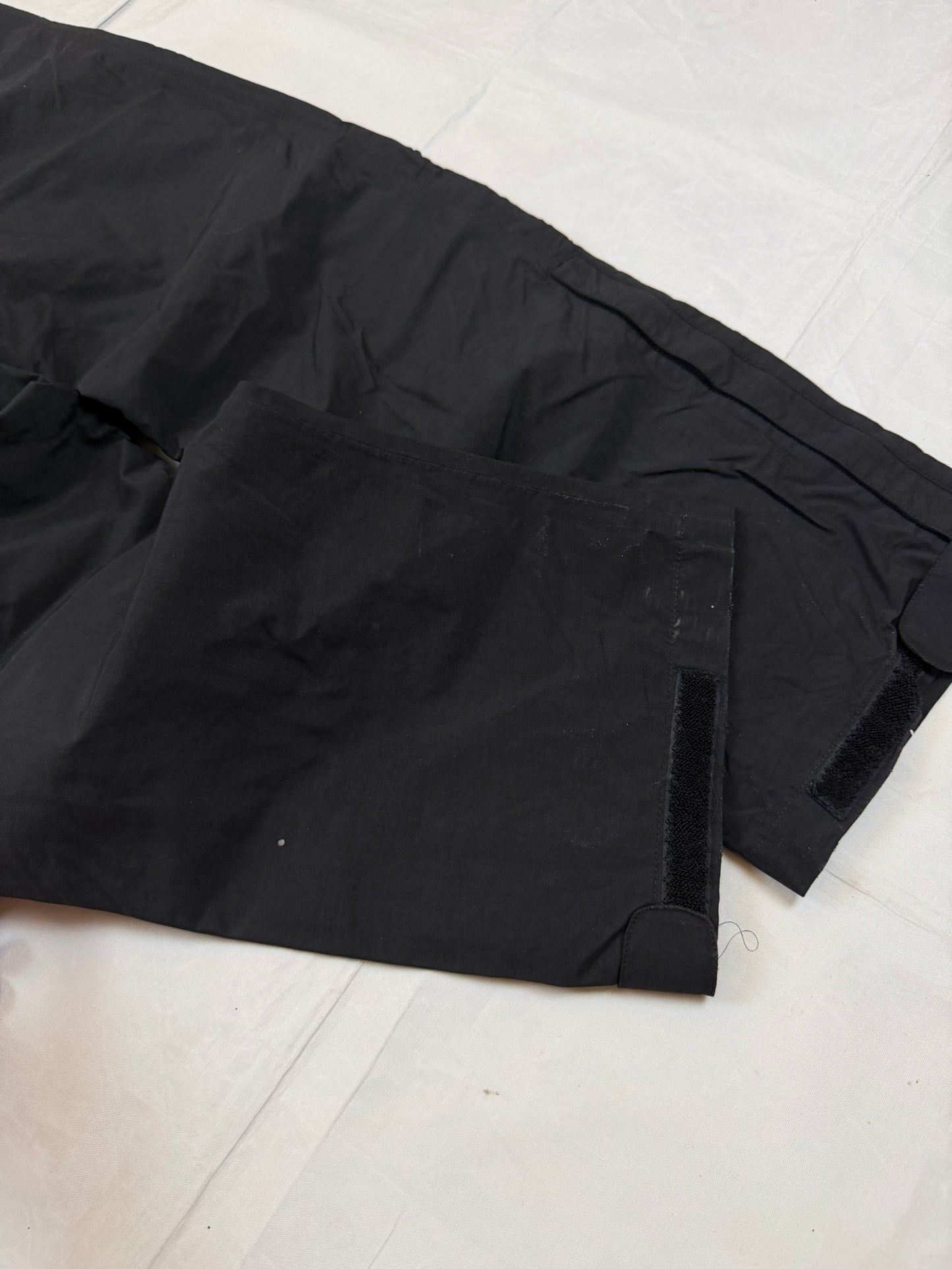 The North Face black hiking trousers with embroidered logo and adjustable Velcro ankle closures.