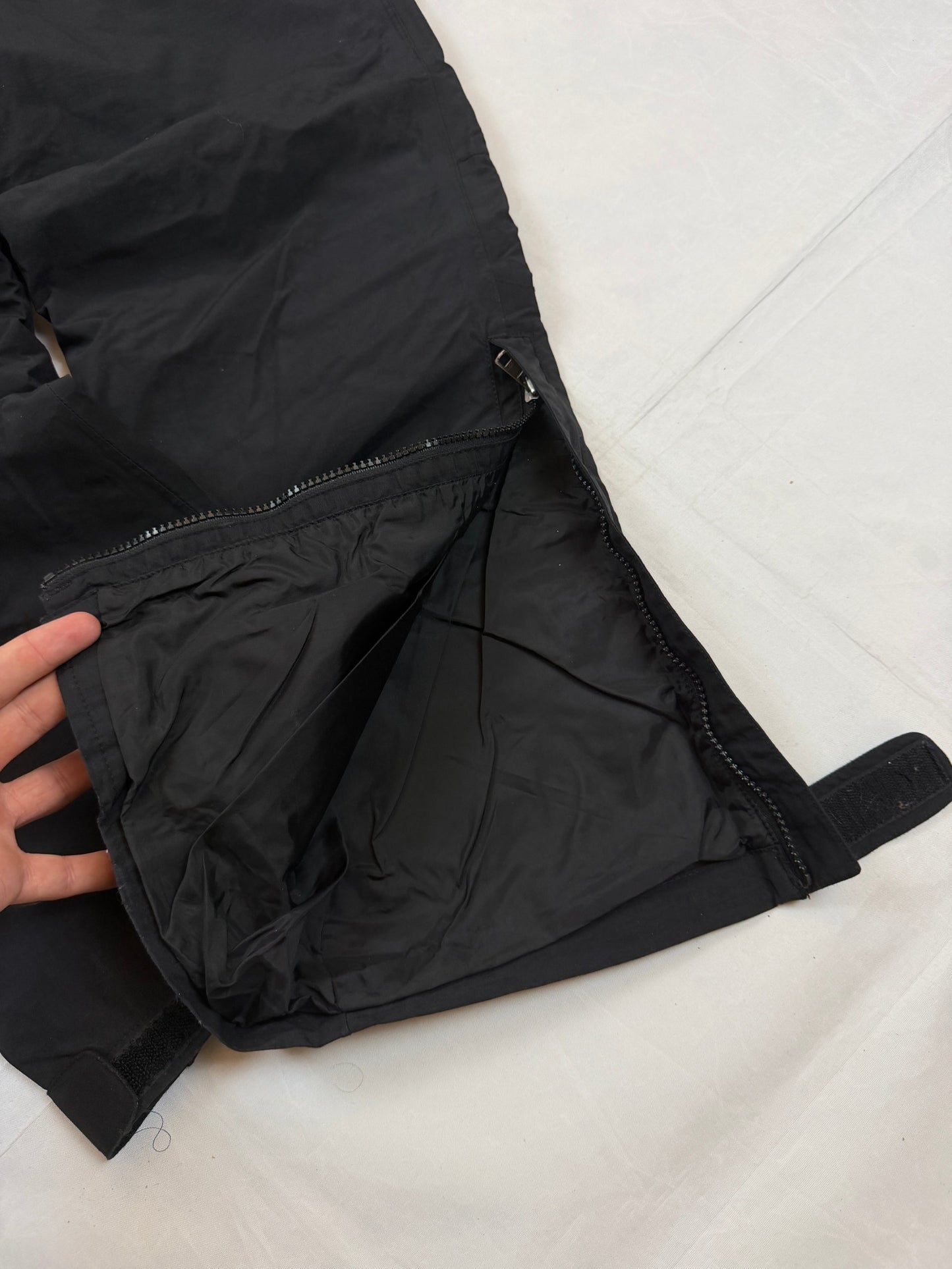 The North Face black hiking trousers with embroidered logo and adjustable Velcro ankle closures.