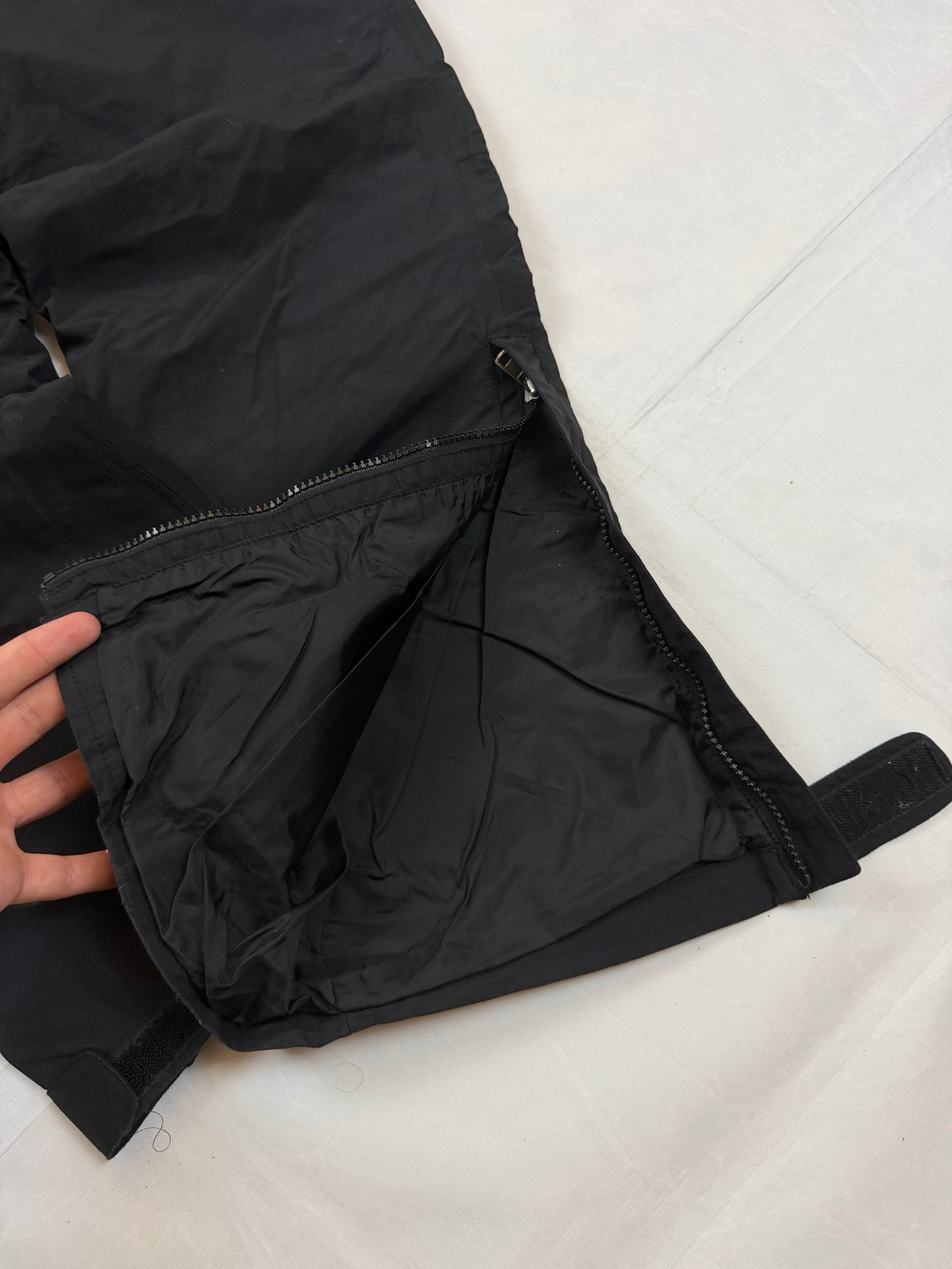 The North Face black hiking trousers with embroidered logo and adjustable Velcro ankle closures.