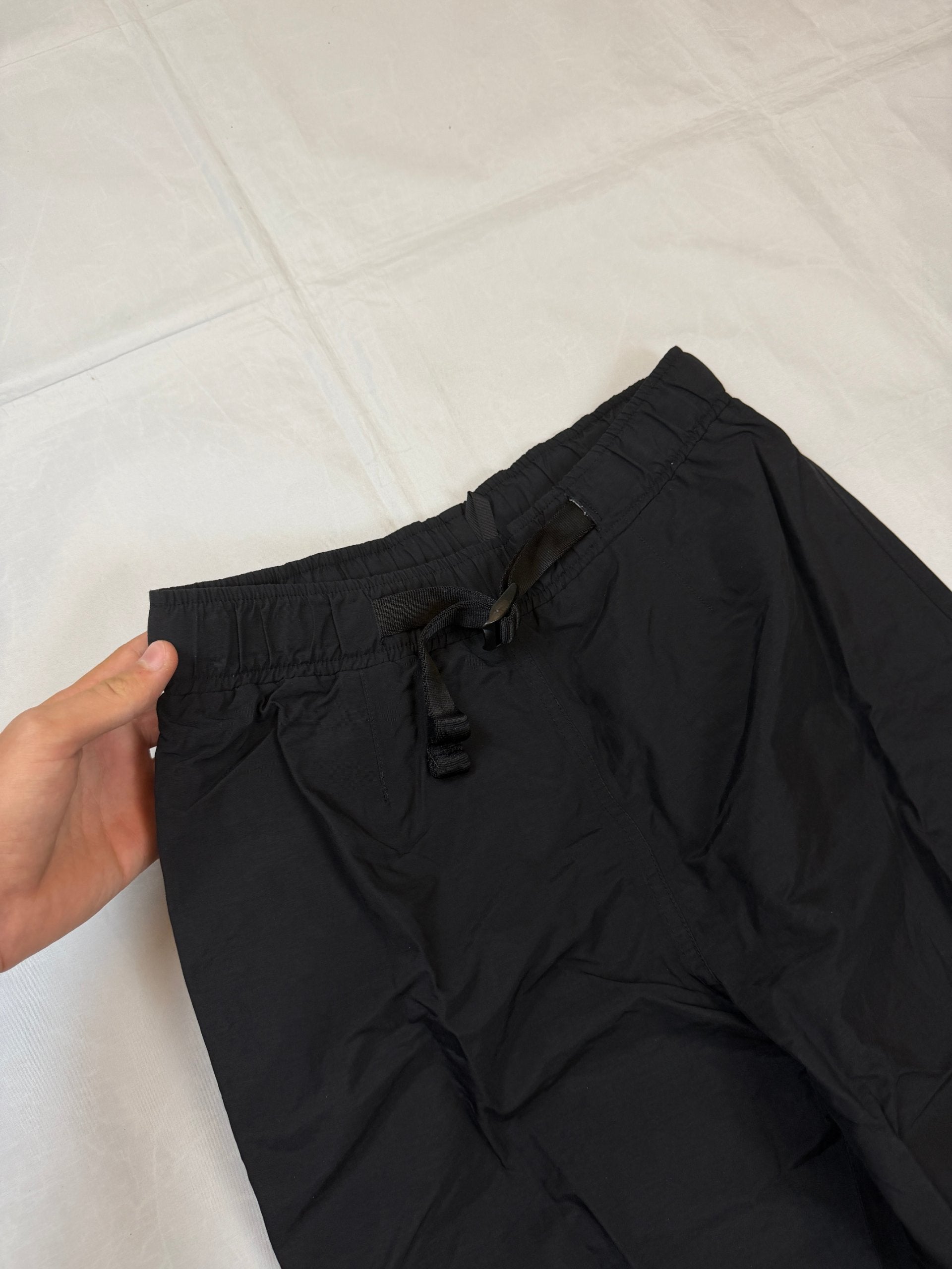 The North Face black hiking trousers with embroidered logo and adjustable Velcro ankle closures.
