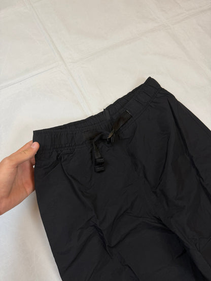 The North Face black hiking trousers with embroidered logo and adjustable Velcro ankle closures.