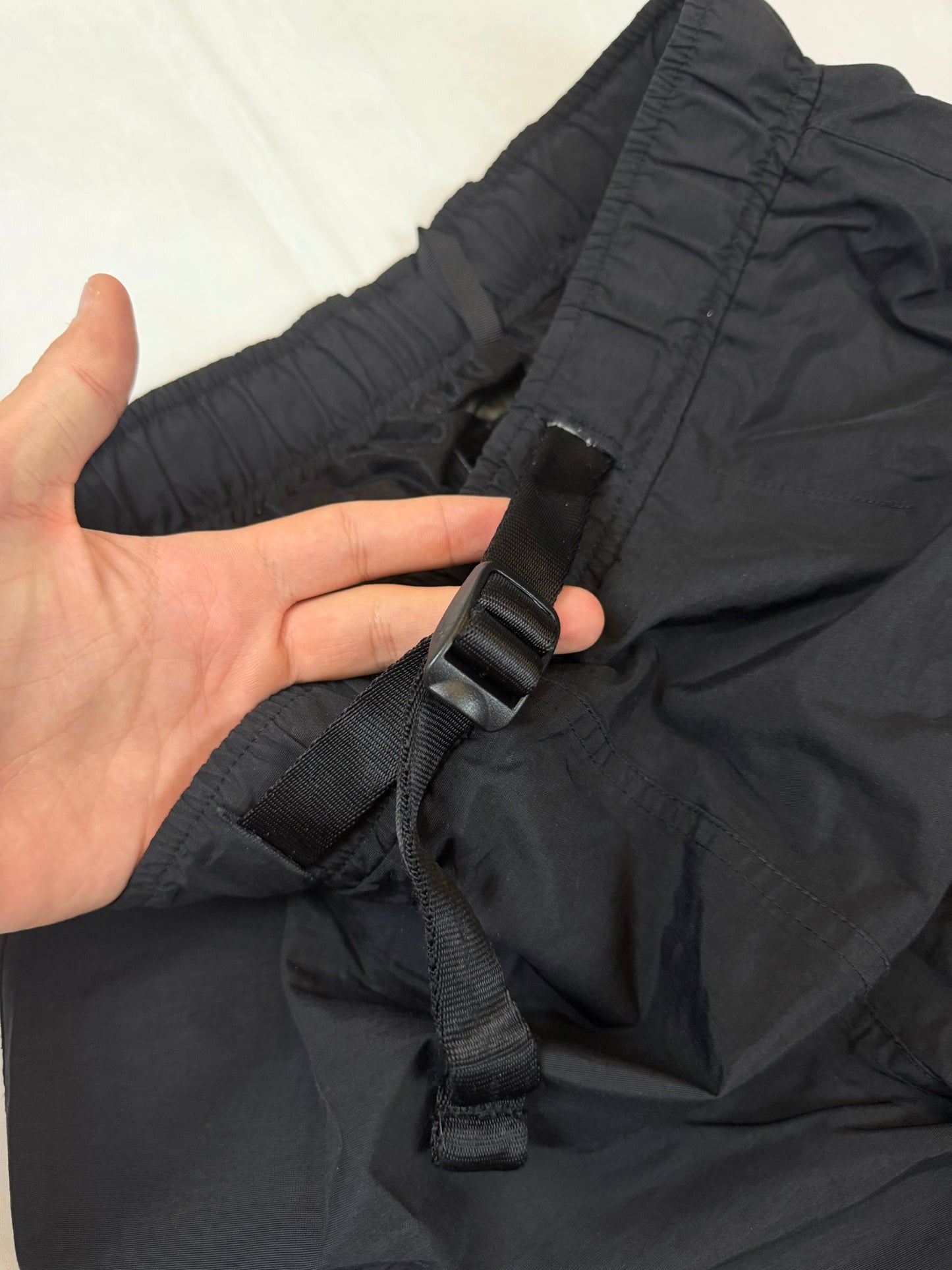 The North Face black hiking trousers with embroidered logo and adjustable Velcro ankle closures.