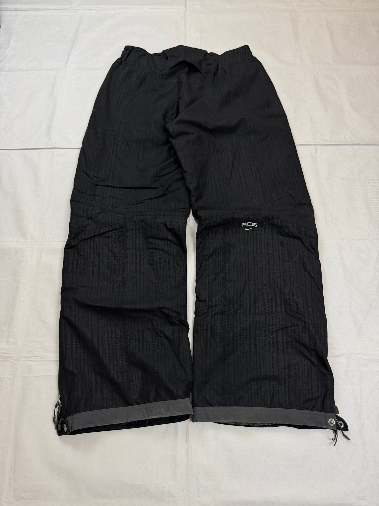 Nike black snow pants with ACG and Gore-Tex logos, adjustable waist, zippered vents.