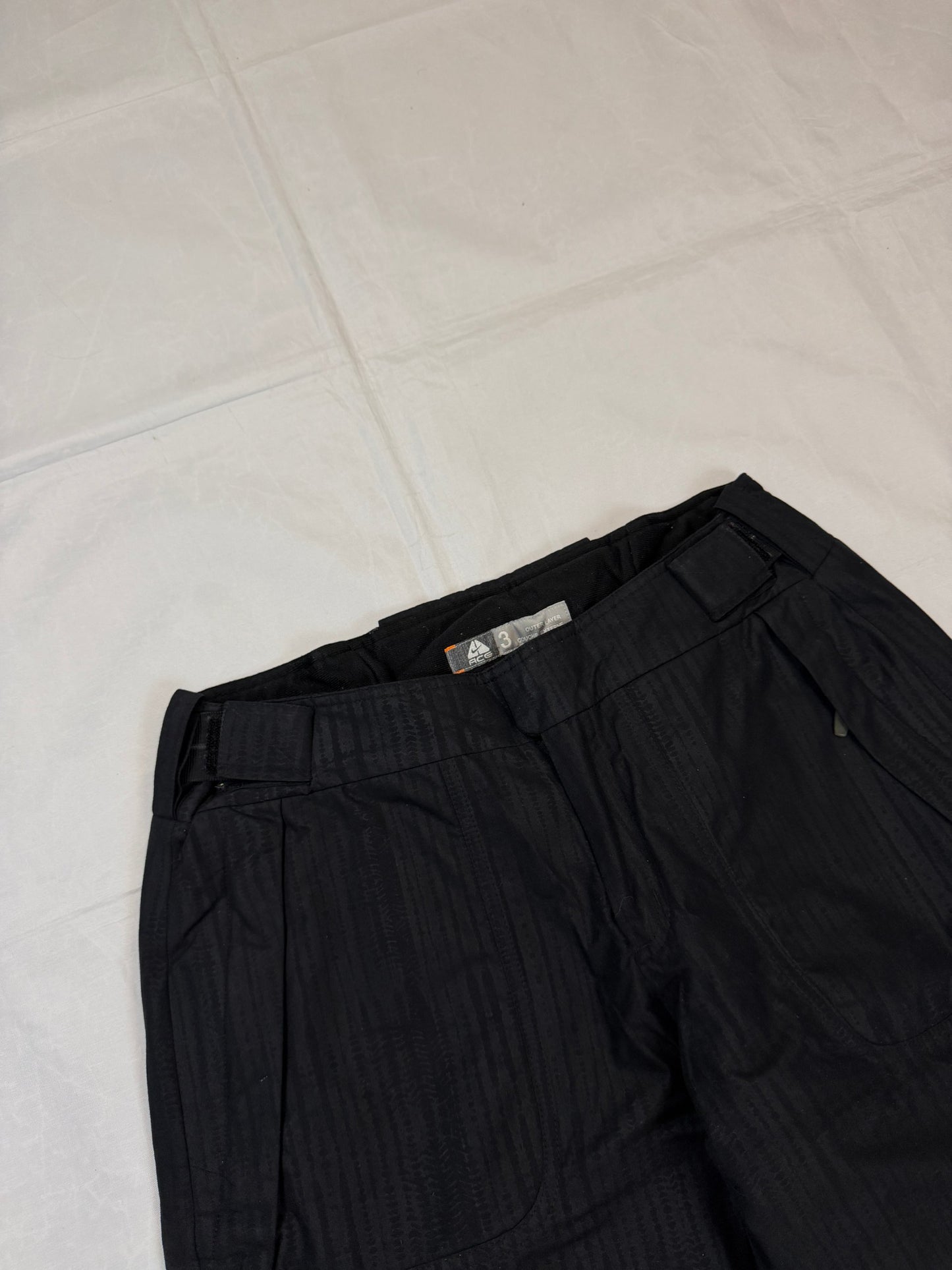 Nike black snow pants with ACG and Gore-Tex logos, adjustable waist, zippered vents.