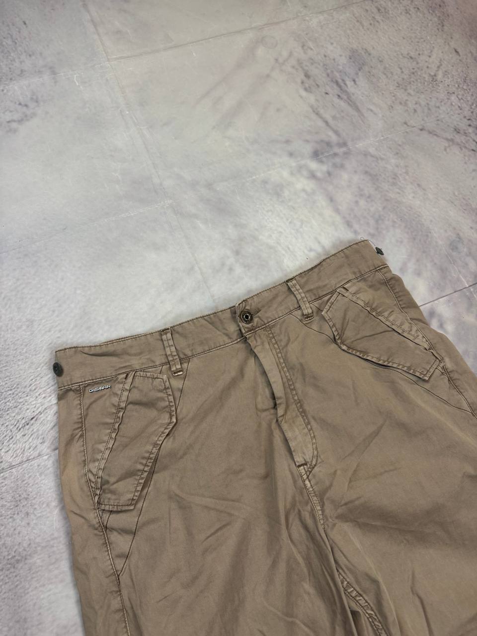 G-Star Raw beige cotton trousers with flap pockets and branded metal button closure.